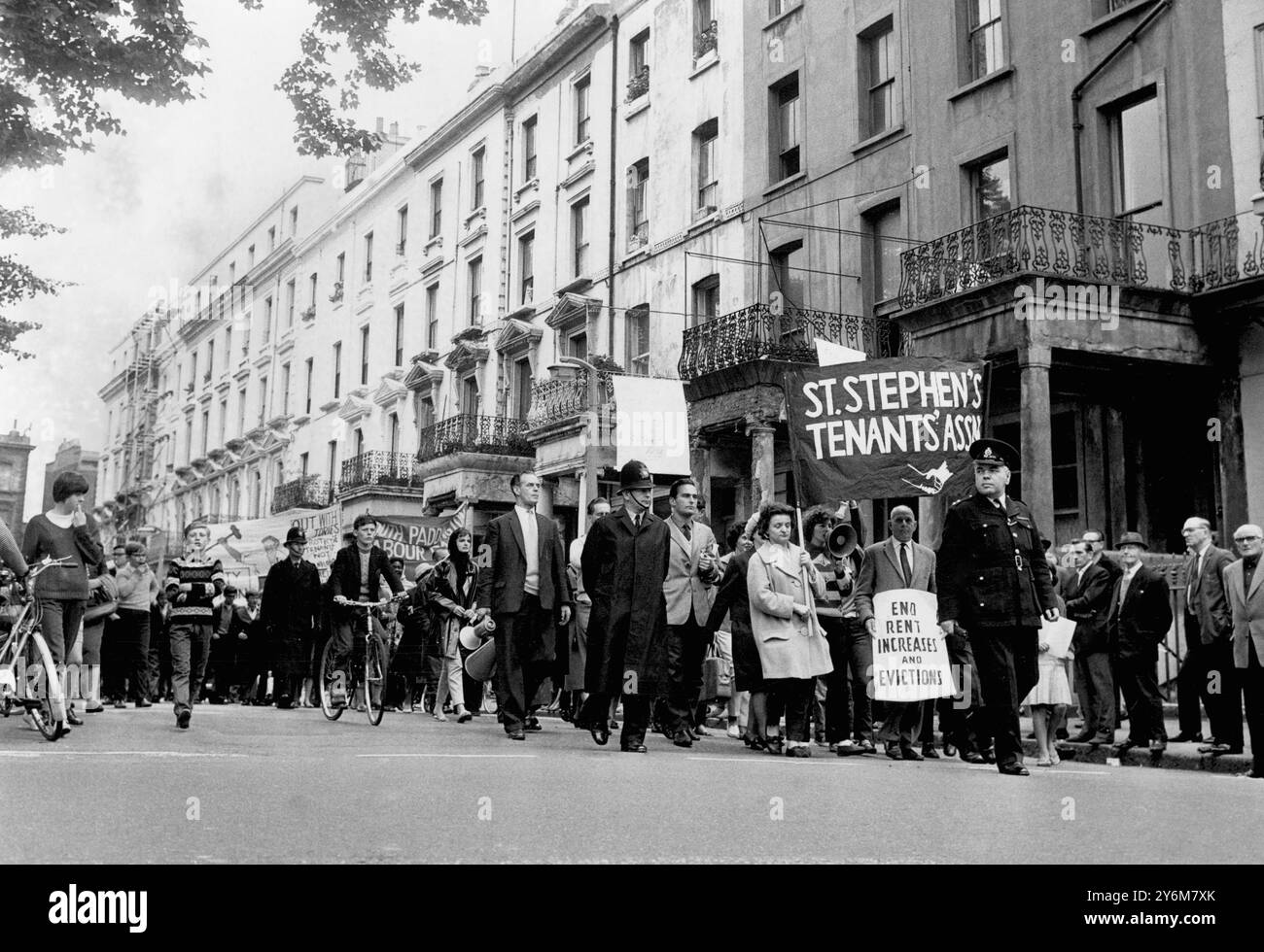 Pour crier « expulser les conservateurs, et non les locataires », les marcheurs protestant contre l'expulsion du M.R. George Cobb et de sa famille de leur sous-sol à Stephen's Gardens, Paddington, se mettent en route. Le cri d'expulsion a été soulevé alors que cette colonne de plusieurs centaines - y compris des femmes avec des bébés - a commencé une marche à travers Paddington au cours de laquelle des lettres adressées au médecin et au président du Comité du logement ont été remises à la mairie. - 25 août 1963 ©TopFoto Banque D'Images