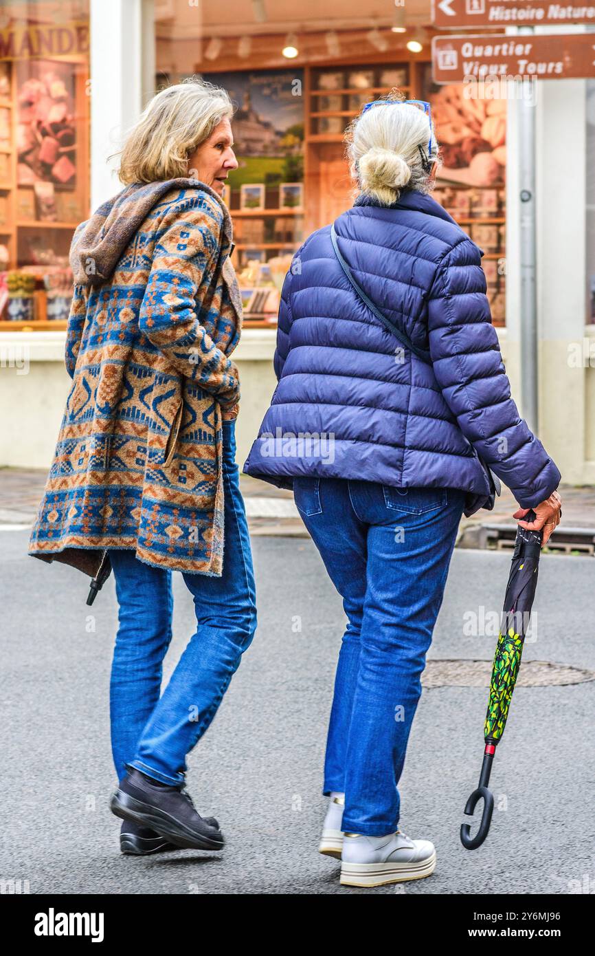 Deux femmes matures en jeans marchant à travers la rue - Tours, Indre-et-Loire (37), France. Banque D'Images