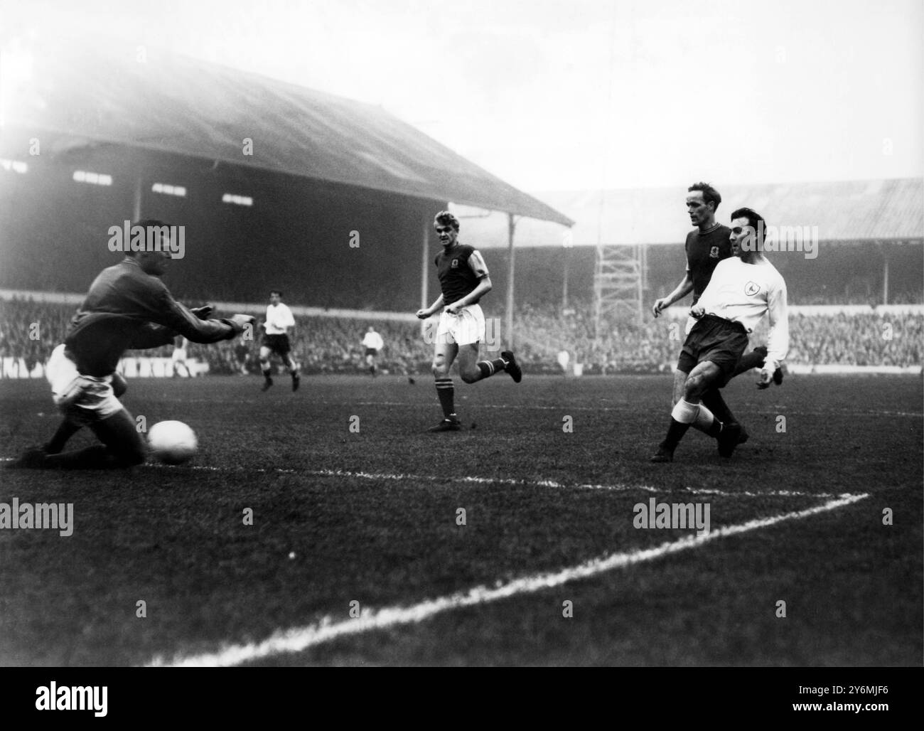 Jimmy Greaves (à droite) bat le gardien d'Aston Villa Withers avec un tir lors du match de division 1 à White Hart Lane le 21 novembre 1964 Banque D'Images