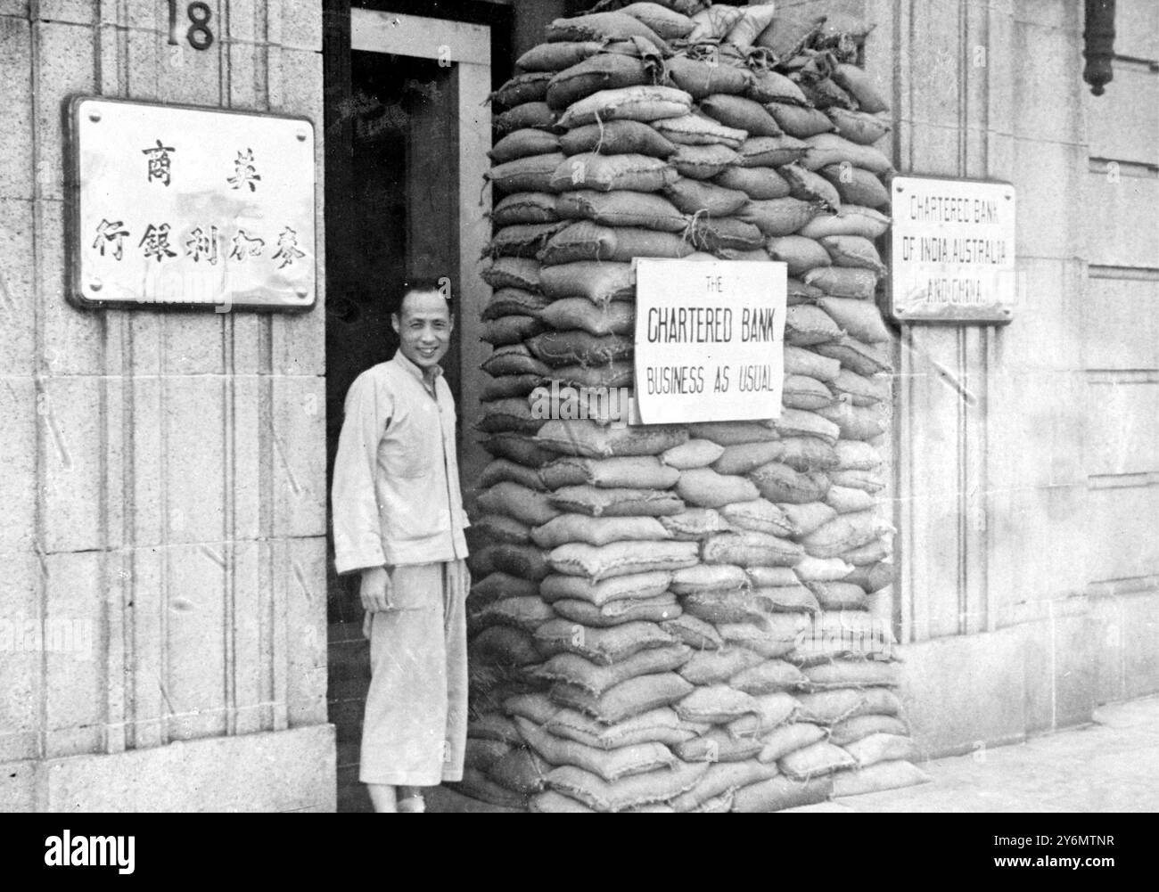 Bien que le commerce de Shanghai ait été presque ruiné par les désastres de la guerre sino-japonaise, certaines maisons d'affaires le long du Bund (front de mer) ont des fenêtres et des portes de sacs de sable comme protection contre les éclats et les balles volants et s'efforcent de continuer comme d'habitude. 27 septembre 1937 Banque D'Images