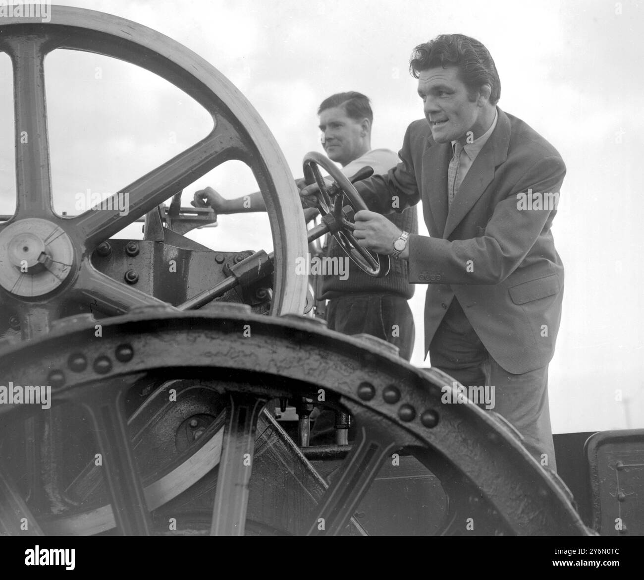 Epping, Essex : L'ancien champion du monde de boxe poids lourds légers Freddie Mills conduit un moteur de traction de 18 tonnes lors du défilé du Hastingwood traction Engine Rally présenté par le club de sport de police d'Epping à Paris Hall Farm, Hasringwood, près d'Epping. 2 octobre 1955 Banque D'Images