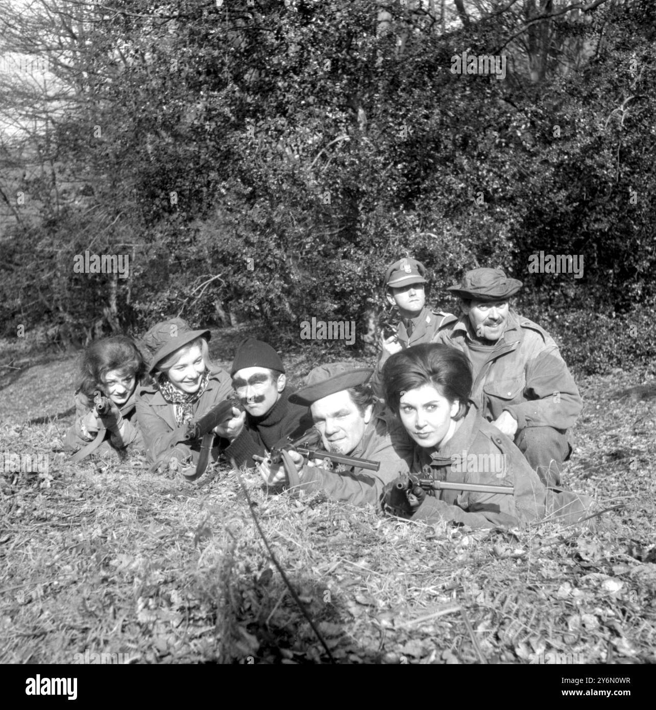 New Forest, Hampshire : la partie "mort ou vivant" n'est qu'une blague, mais ce groupe de "bandits", photographiés se cachant dans la New Forest, ici aujourd'hui, sont vraiment recherchés. Par la compagnie A du 4th/5th BTN, Royal Hampshire Regiment, territorial Amy. - - Le groupe de tir de gauche à droite première rangée : TV Stars Anita Harris et Nancy Roberts, John Eden, député de Bournemouth West : boxeur Freddie Mills : et mannequin Gloria Gale, sont pourchassés par l'Armée territoriale dans des opérations de sécurité intérieure. Note de confiance : le territorial s'attend à rassembler ces personnalités "hors-la-loi" et 30 autres civils "Ba Banque D'Images