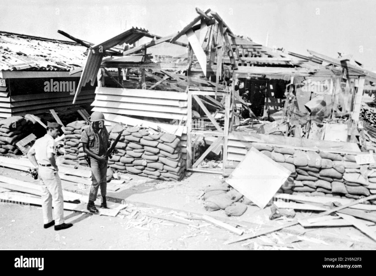 Saigon : un aviateur et un soldat des États-Unis regardent les dommages causés à l'un des bâtiments détruits par des tirs de roquettes et de mortier communistes sur la base aérienne de Tan son Nhut près d'ici le 24 février. Quatre Américains ont été tués dans l'attaque. 29 février Banque D'Images