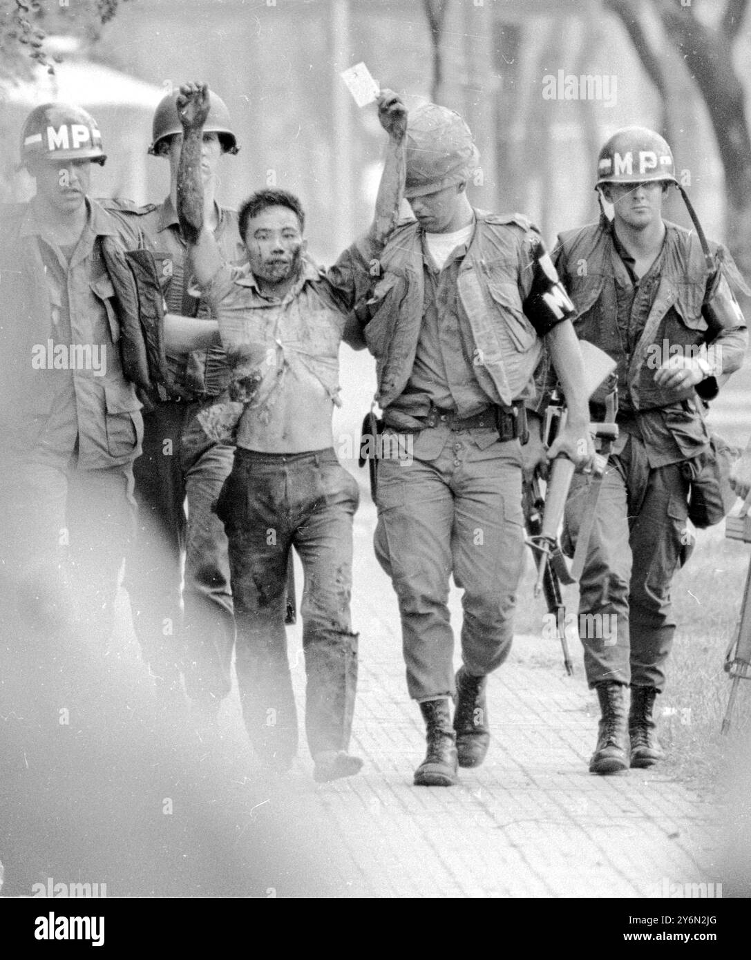 Siagon : un suspect viet Cong, soupçonné d'être l'un des membres de l'escouade suicide qui ont pris d'assaut l'ambassade des États-Unis ici et occupé une partie de celle-ci pendant une courte période le 31 janvier, étant conduit vers une jeep par la police militaire américaine. 3 février 1968 Banque D'Images
