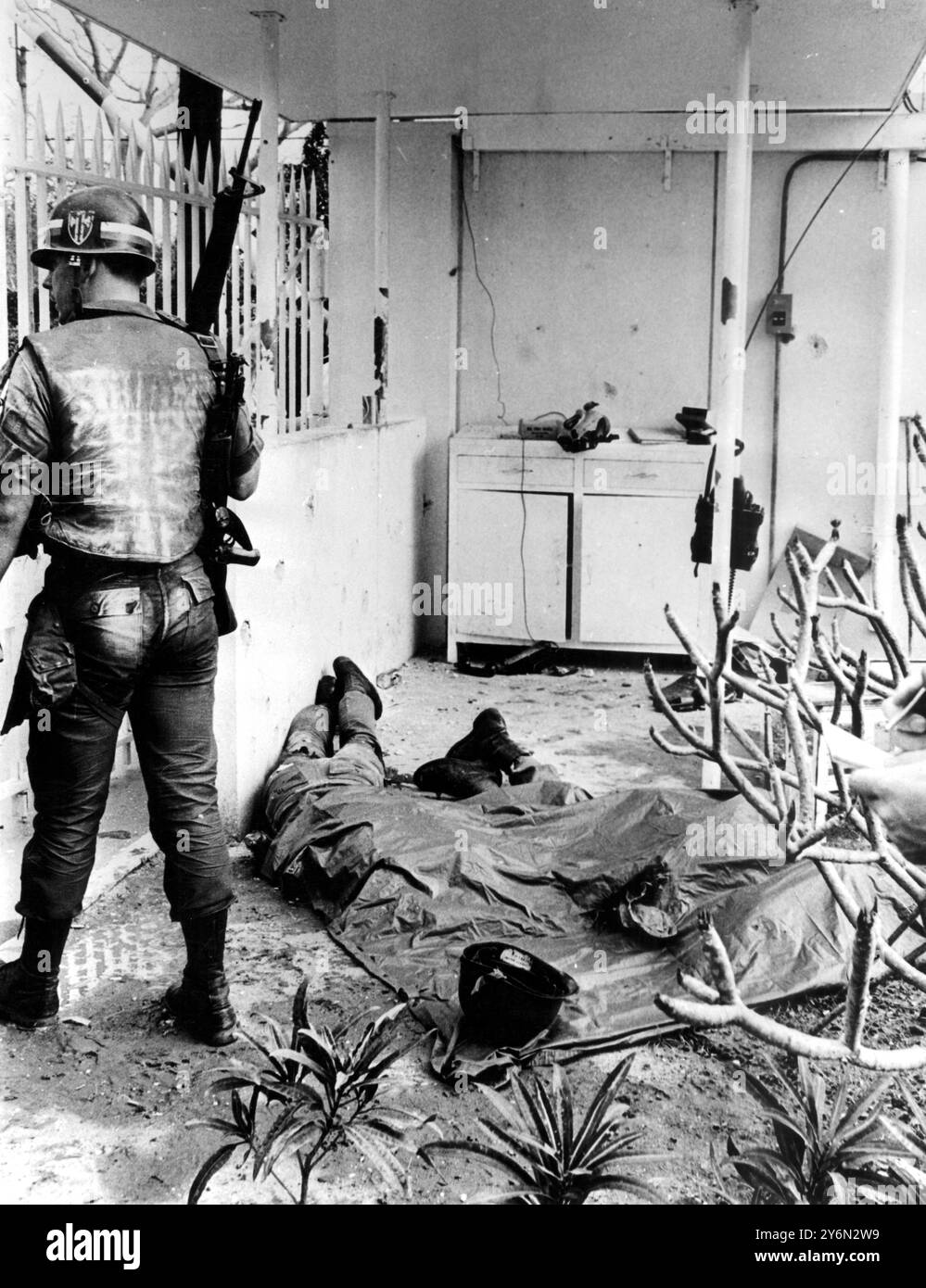 Les corps de deux policiers militaires de l'armée américaine gisaient sous une bâche à l'ambassade américaine le 31 janvier 1968. Ils ont été tués lorsque les guérilleros Viet Cong ont envahi le bâtiment et en ont gardé possession pendant six heures. Les assaillants ont été mis en déroute par des parachutistes qui ont atterri sur le toit du bâtiment en hélicoptère. Banque D'Images