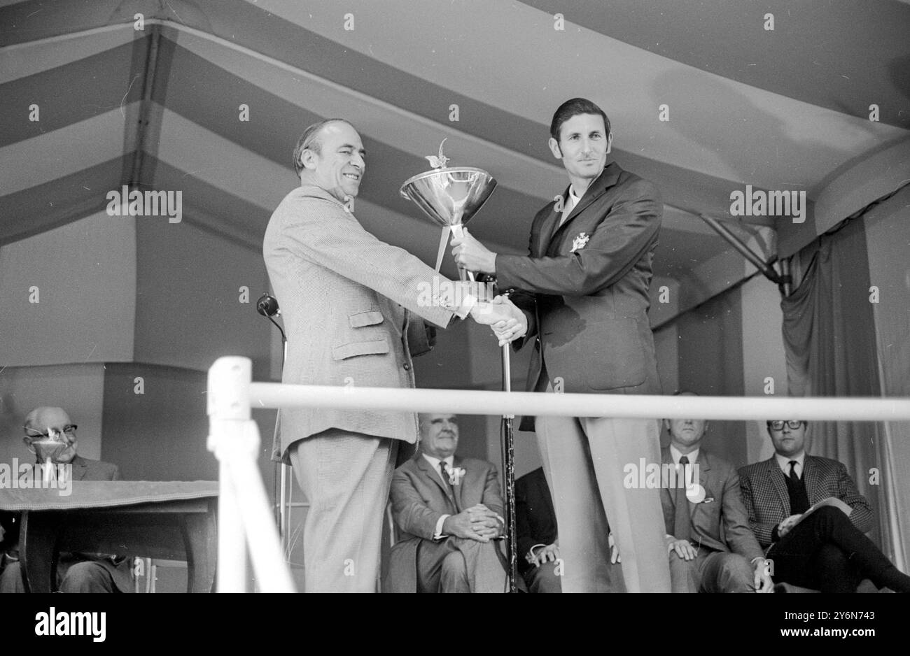 Wentworth, Angleterre : le gaucher néo-zélandais Bob Charles reçoit le trophée de m. Philip Bulpit, chariman de carreras, après avoir remporté la finale du Championnat du monde de golf piccadilly. Il a battu l'américain Gene Littler dans une finale palpitante de 36 trous. Ils étaient tous carrés après le 36e et au match de la mort suden qui a suivi, Charles a fait un merveilleux aigle trois au 37e pour remporter le titre et le premier prix de £5 750. 11 octobre 1969 Banque D'Images