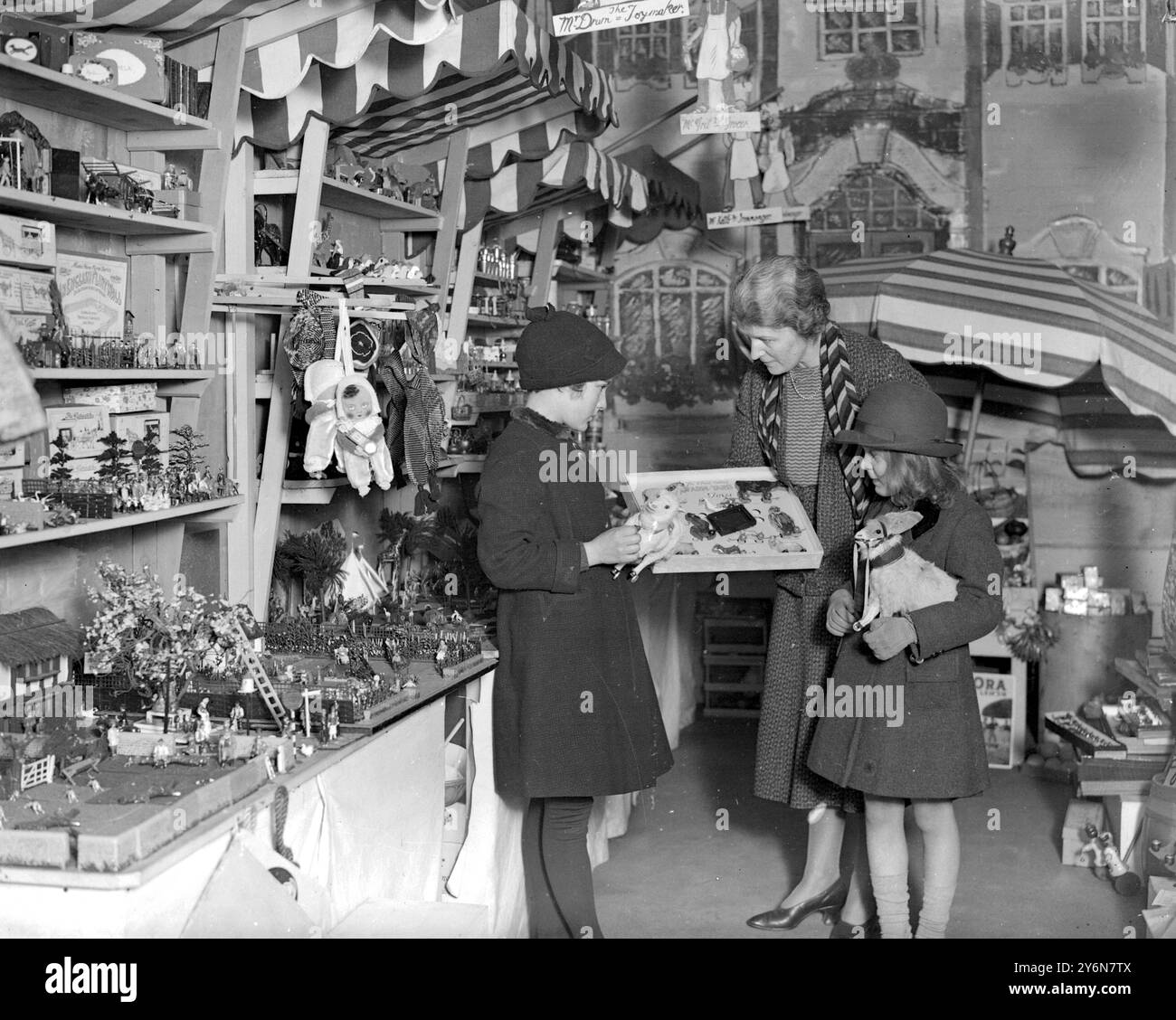 Lady Verney (écharpe rayée) dans le jouet et la librairie elle a ouvert dans le garage de sa maison dans Princes Gardens. 5 décembre 1932 Banque D'Images