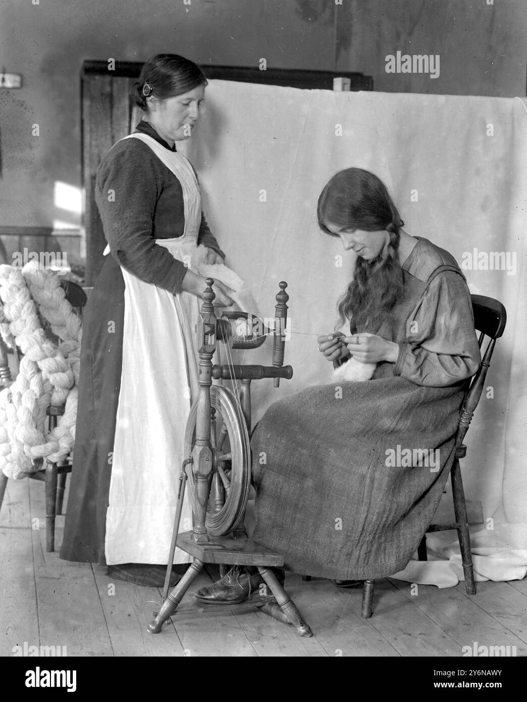 Tissage à Willesden - où le centre du travail de la Reine pour les femmes a pris fin à Willesden un certain nombre de femmes ont été jetées du travail qui étaient tout à fait inadaptées au marché du travail ordinaire. Mlle Violet Alstom instruisant une des femmes dans l'art de filer. Banque D'Images