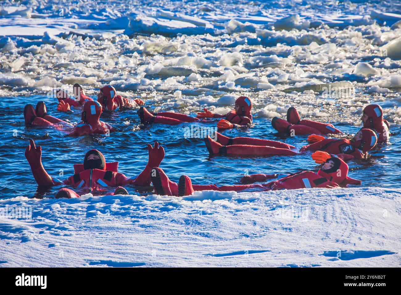 Scandinavie, Laponie, Finlande. Golfe de Botnie. Sampo, brise-glace. Touristes en combinaisons rouges pour nager dans la piste du brise-glace Banque D'Images