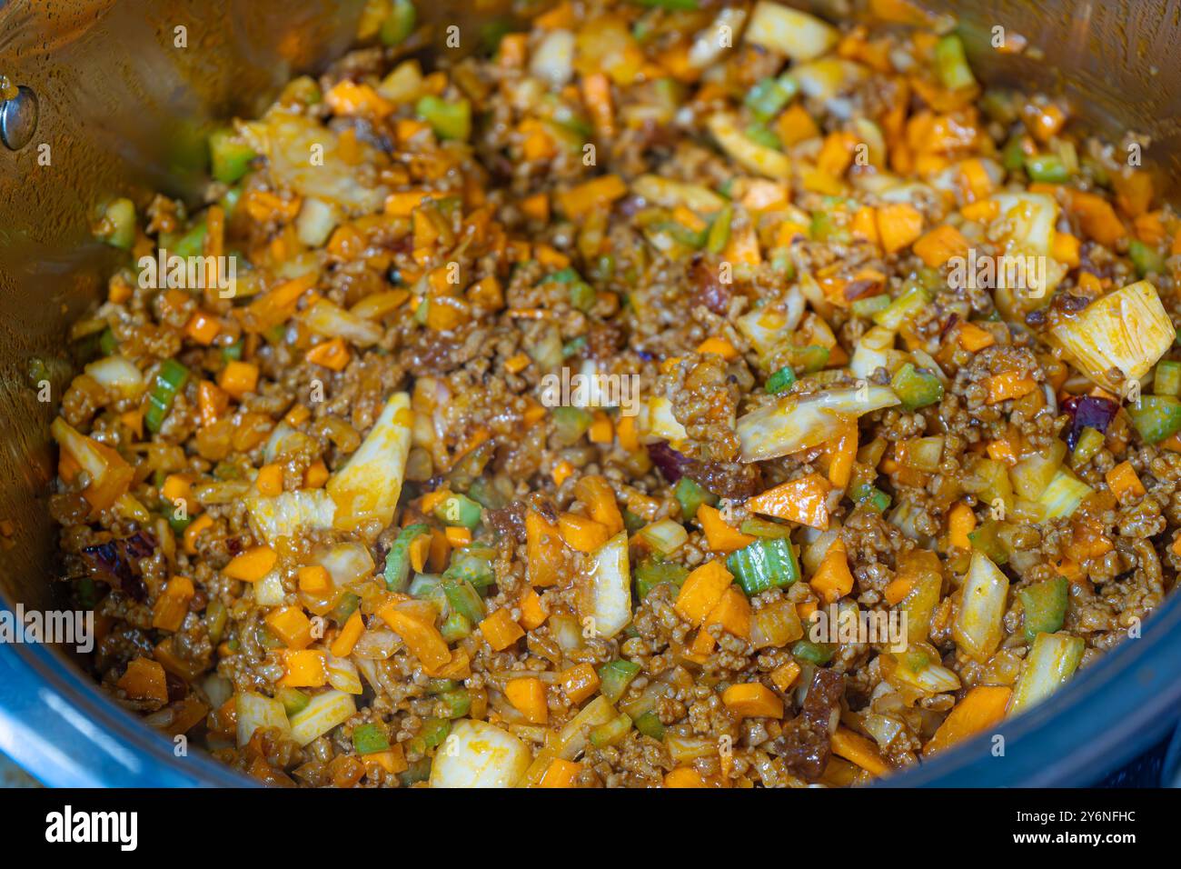 Gros plan Homecooking. Préparation de sauce bolognaise maison. Préparation de sauce tomate. poix de mire sautée. Cuisson des tomates. Brunissement du bœuf haché. Banque D'Images