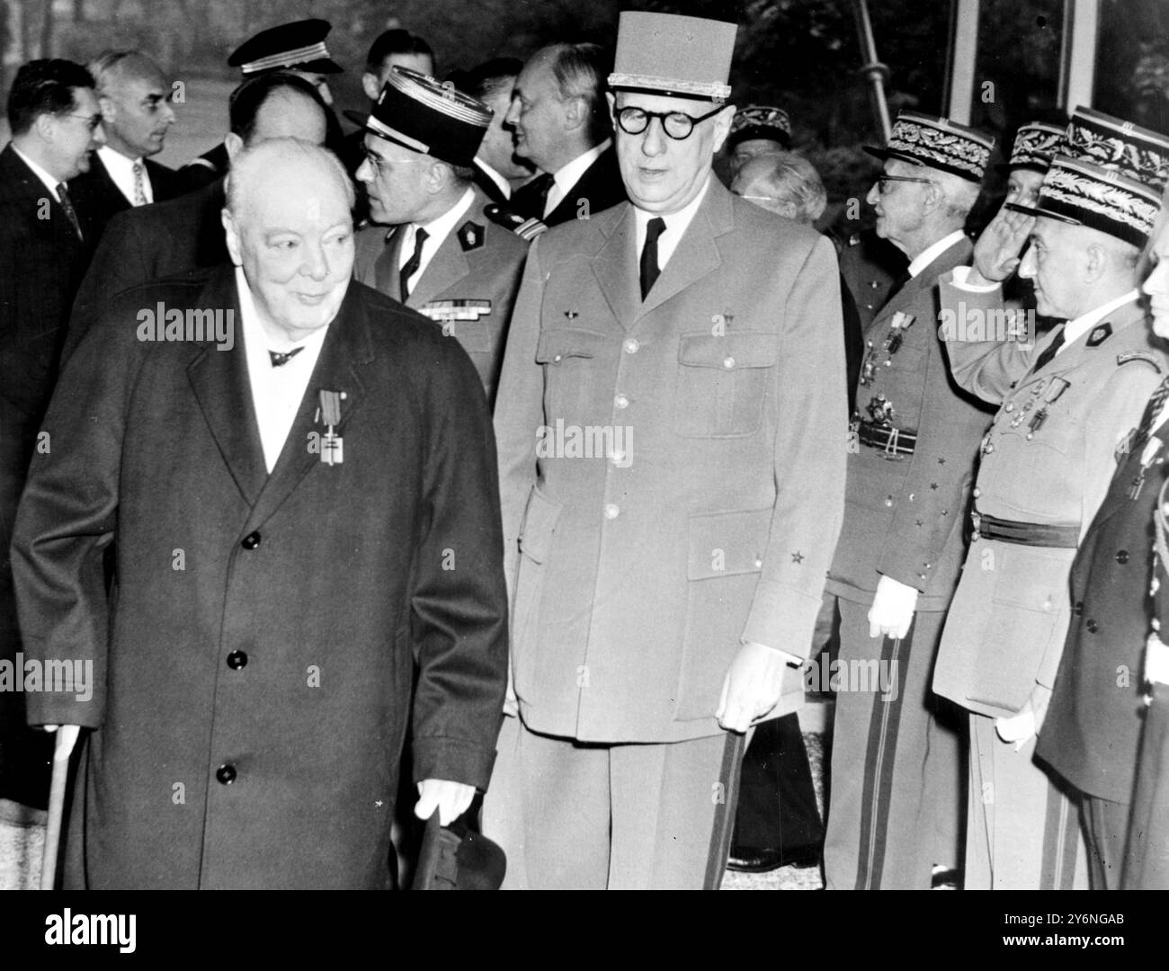 Paris, France : rayonnant joyeusement, Sir Winston Churchill se promène ce matin dans le jardin de l’Hôtel Matignon, portant la médaille avec laquelle le premier ministre français Charles de Gaulle (portant des glases) vient de le décorer. La médaille est la Croix de libération française, l'ordre a été créé par le général lors de la dernière guerre ; aujourd'hui il y en a 1 054 détenteurs, mais seulement 637 sont encore en vie. Sir Winston n'est que le troisième détenteur abandonné de la décoration. Après la cérémonie, il y a eu un déjeuner privé pour les deux hommes. 6 novembre 1958 Banque D'Images