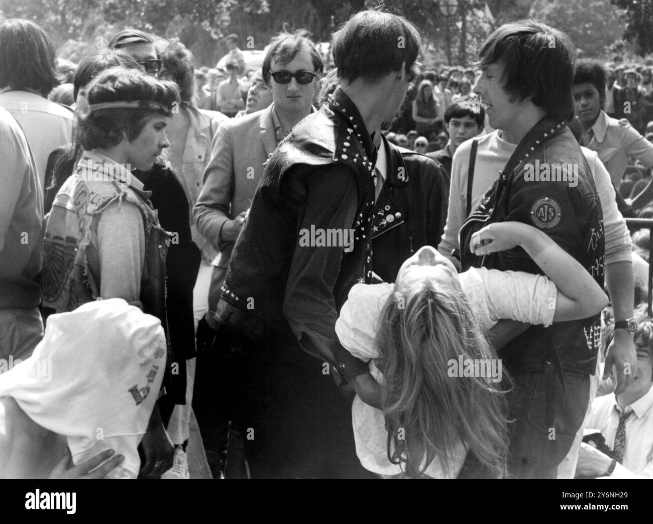 Casualty au concert des Stones. Une fan de pop fille qui a peint au concert en plein air 'come-back' des Rolling Stones, est emportée par deux membres des 'Hell's Angels', qui étaient présents au concert pour protéger le groupe et contrôler les fans à Hyde Park à Londres. Environ 200 000 fans de pop ont assisté au concert, qui a marqué la première apparition publique du groupe pendant 14 mois. Au moins 250 victimes ont été soignées lors du concert. Douze personnes ont été arrêtées lors de distrubances au concert. Banque D'Images