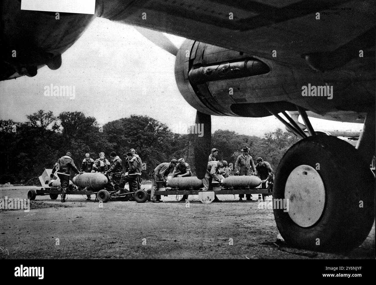 Bombing Up : les équipages au sol mettent en place des chariots de bombes à roues pour bombarder l'une des nombreuses « forteresses volantes » géantes maintenant dispersées sur les aérodromes britanniques, où leurs équipages attendent impatiemment le moment pour un assaut combiné sur l'Allemagne. Août 1942 ©2004 Topfoto Banque D'Images