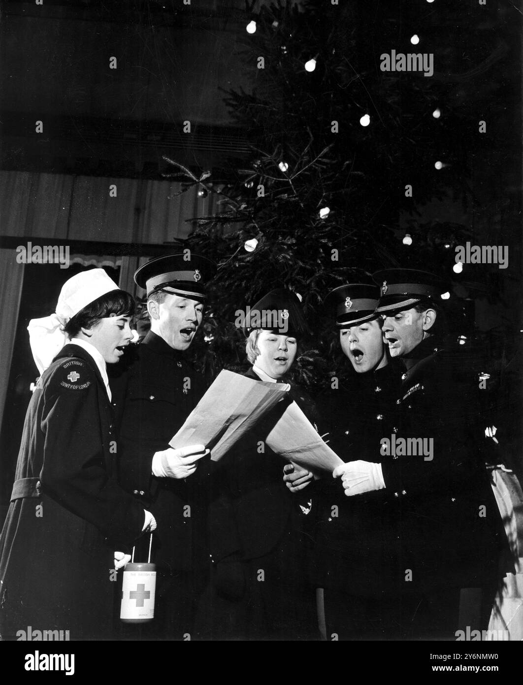 Un sapin de Noël scintillant donne l'air festif droit à un chant chanté par (de gauche à droite) l'infirmière Gloria Graeme ; le caporal du cheval Colin Misseneder ; le soldat Diane Palmer ; le caporal Mike Febbrarro et le caporal Lucien Scott Quatermaster de l'escadron. Ce soir (jeudi) un certain nombre de membres de la Household Cavalry, et d'autres, chanteront des chants pour le plaisir des Londoniens afin de collecter des fonds pour la division Westminster de la Société de la Croix-Rouge britannique. Leur itinéraire sera : Hyde Park Barracks Yard, travers Square, Montpelier Square, cheval place, Brompton Square, restaurant Casa Pepi, Brom Banque D'Images