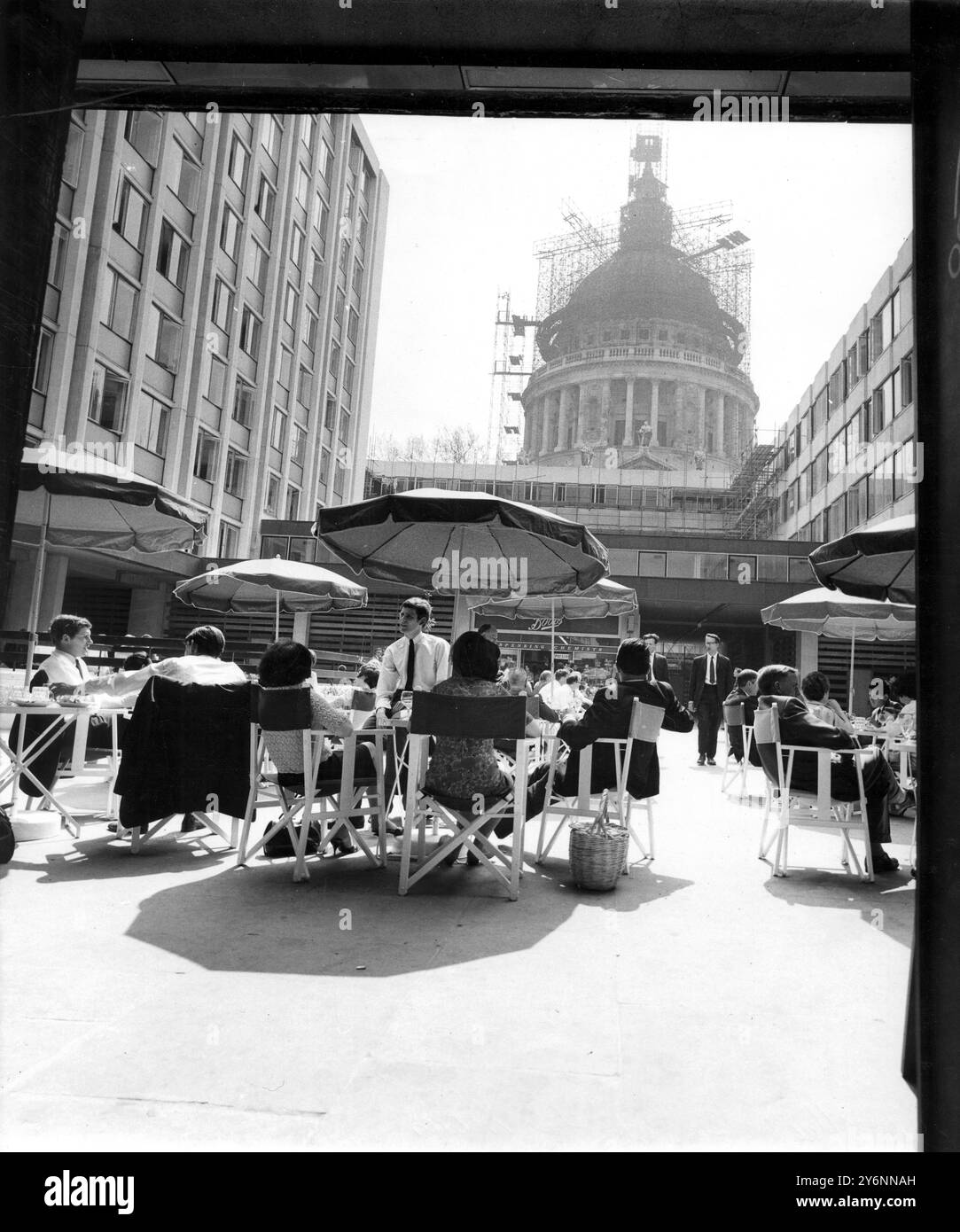 Flanqués par les bâtiments modernes du Paternoster Development, les travailleurs de la ville profitent de leur heure de déjeuner avec une touche continentale sous le soleil de mai. La cathédrale Saint-Paul offre une toile de fond impressionnante - 2 mai 1966 Banque D'Images