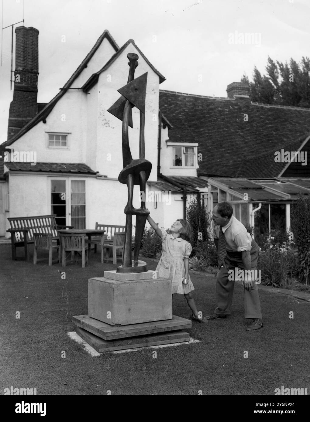 Henry Moore, sculpteur dans sa maison de campagne -'Hogland ' Perry jardin, beaucoup Hadaam, Herts en arrière-plan est le 15 siècle chalet où il vit. Avec le sculpteur est Marie, sa fille de 6 ans 1952 Banque D'Images