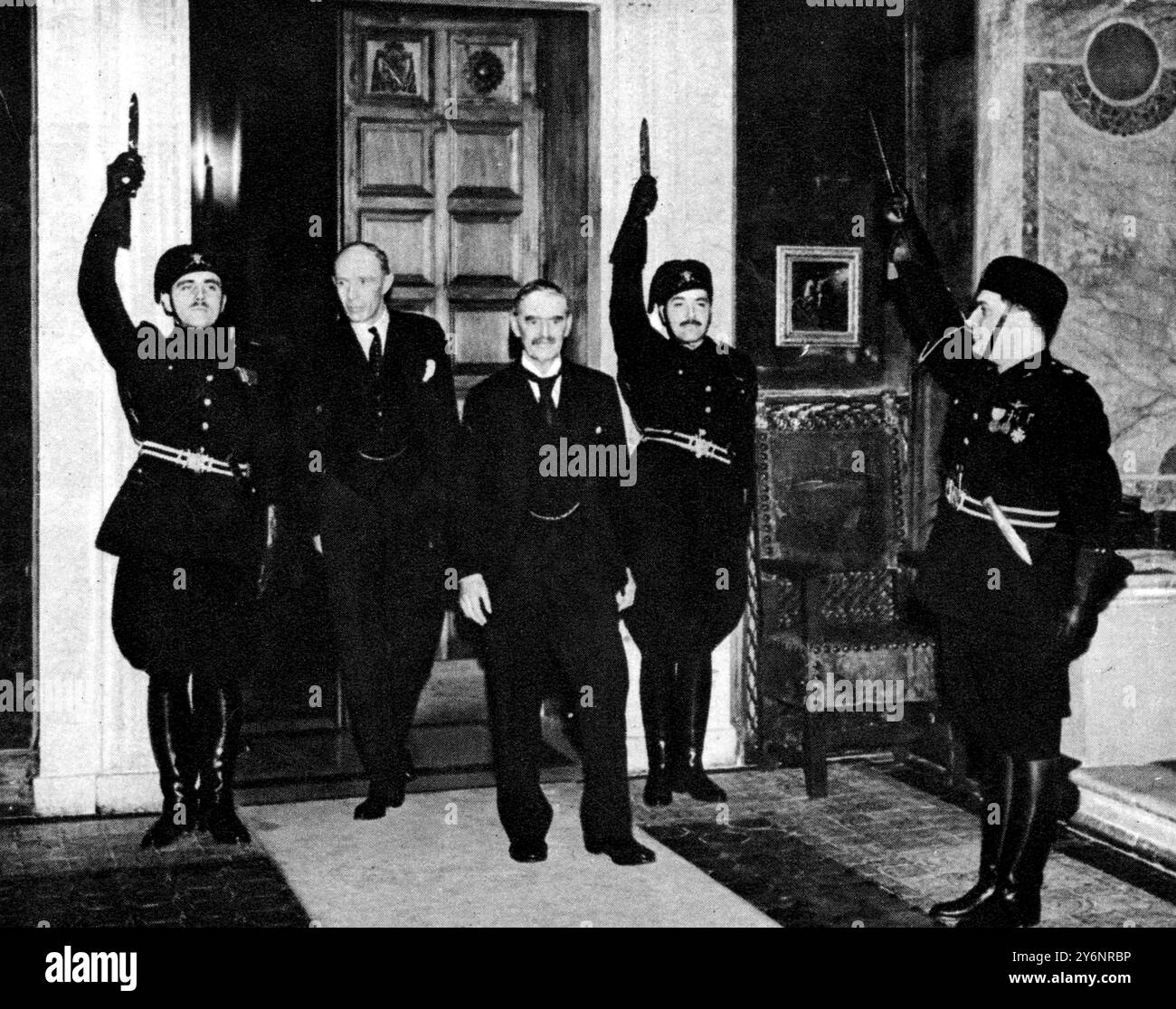 M. Chamberlainand Lord Halifax salué par les gardes fascistes avec des poignards tirés : les ministres britanniques arrivant au Palazzo Venezia pour des conversations avec Signor Mussolini lors de leur visite à Rome janvier 1939 ©2004 Topfoto Banque D'Images