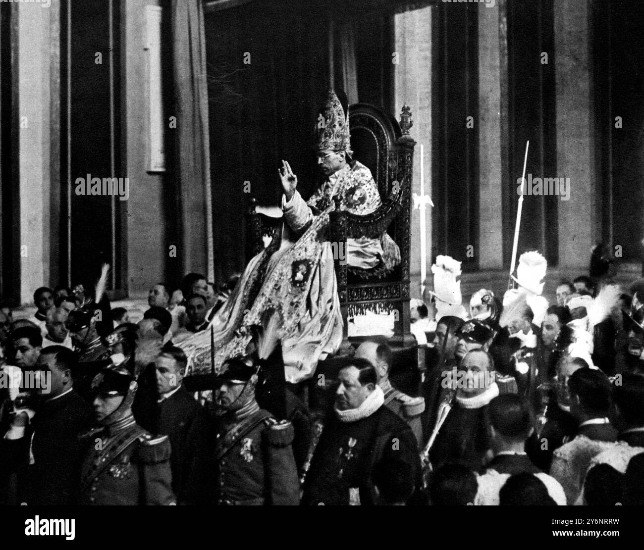 Comment le nouveau Pape a fait son progrès à travers Saint Pierre le jour de son couronnement : Pie XII assis dans la Sedia Gest atoria, portant sa mitre de bijoux et levant la main en bénédiction, porté en processionamid sa suite mars 1939 ©2004 Topfoto Banque D'Images
