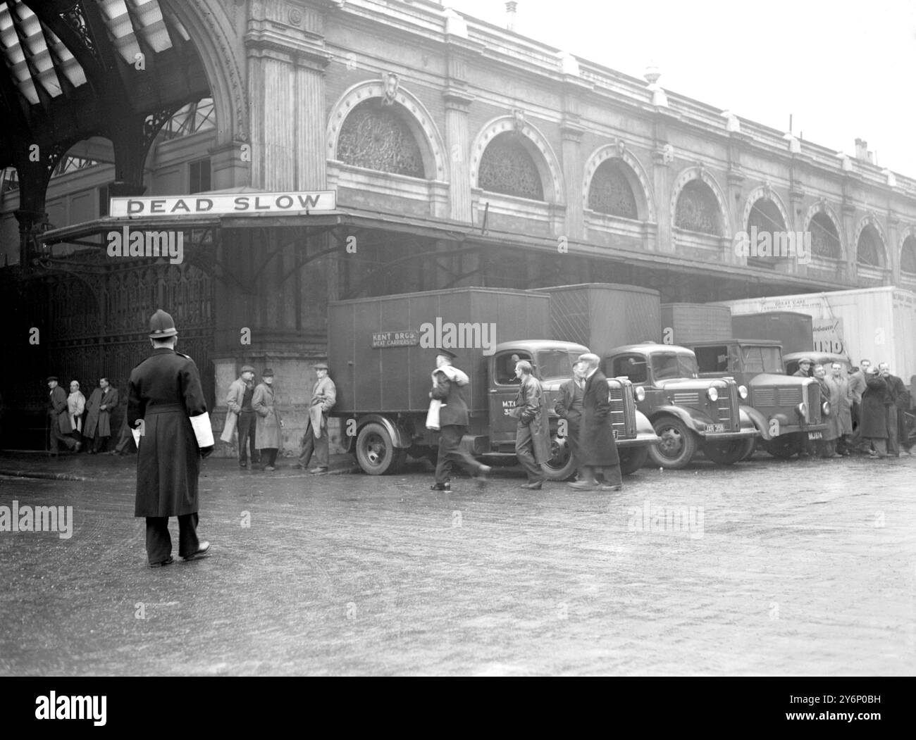 Smithfield Market, un panneau de signalisation « Dead slow » situé à proximité, décrit adéquatement les camions au ralenti et les chauffeurs de poids lourds qui se tiennent à proximité du marché en grève. - - 3 janvier 1950 Banque D'Images