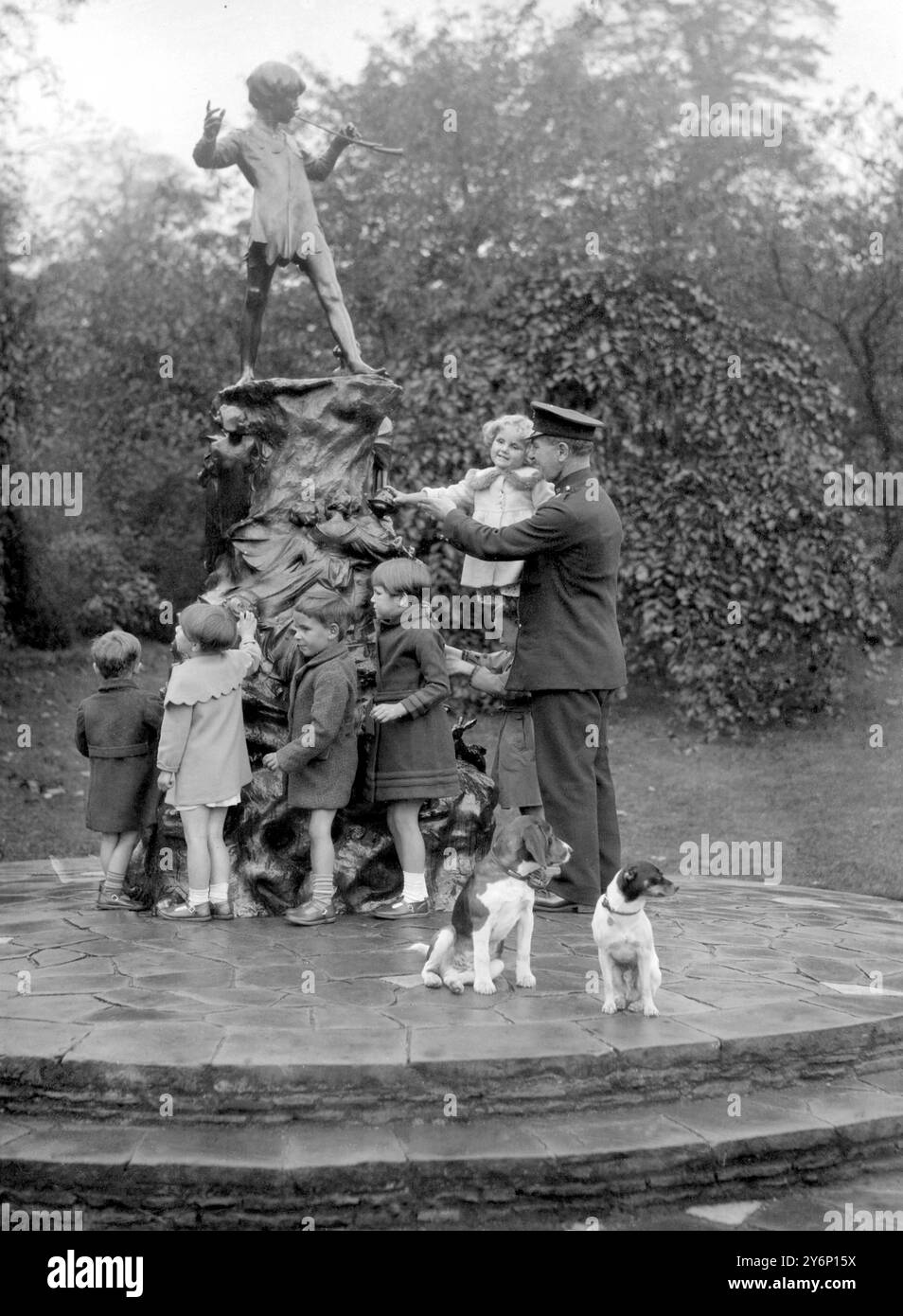 Les Blind Babies de la Sunshine Home à East Grinstead ont fait une visite touristique lors de leur sortie annuelle à Londres. En visitant les jardins de Kensington, ils ont été autorisés à toucher la statue de Peter Pan. 1er octobre 1934 Banque D'Images