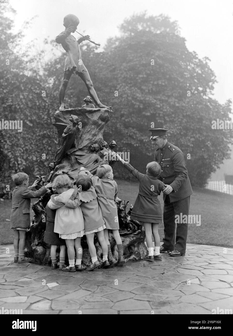 Les Blind Babies de la Sunshine Home à East Grinstead ont fait une visite touristique lors de leur sortie annuelle à Londres. En visitant les jardins de Kensington, ils ont été autorisés à toucher la statue de Peter Pan. 1er octobre 1934 Banque D'Images