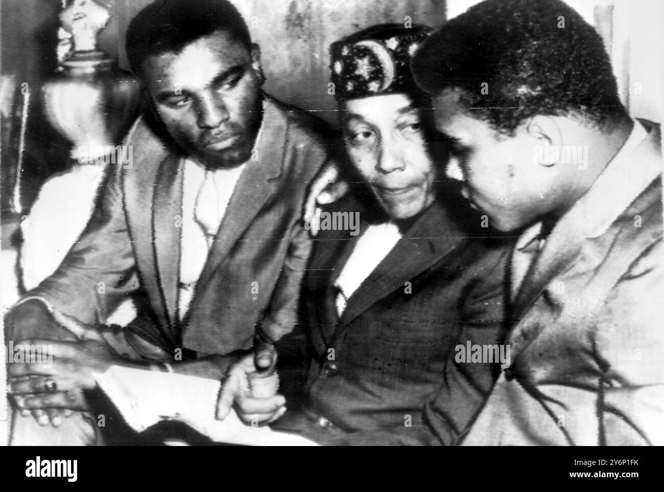 Cassius Clay le nouveau champion poids-lourds du monde avec son bras autour du leader musulman noir Elijah Muhammad Poole lors de la rencontre à gauche le frère de Clay Rudolph Clay le 16 mars 1964 Banque D'Images