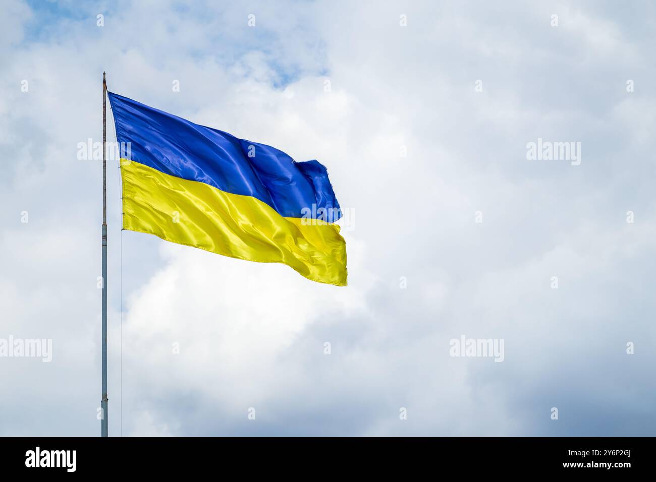 Un drapeau endommagé de l'Ukraine vole sur fond d'un ciel nuageux Banque D'Images