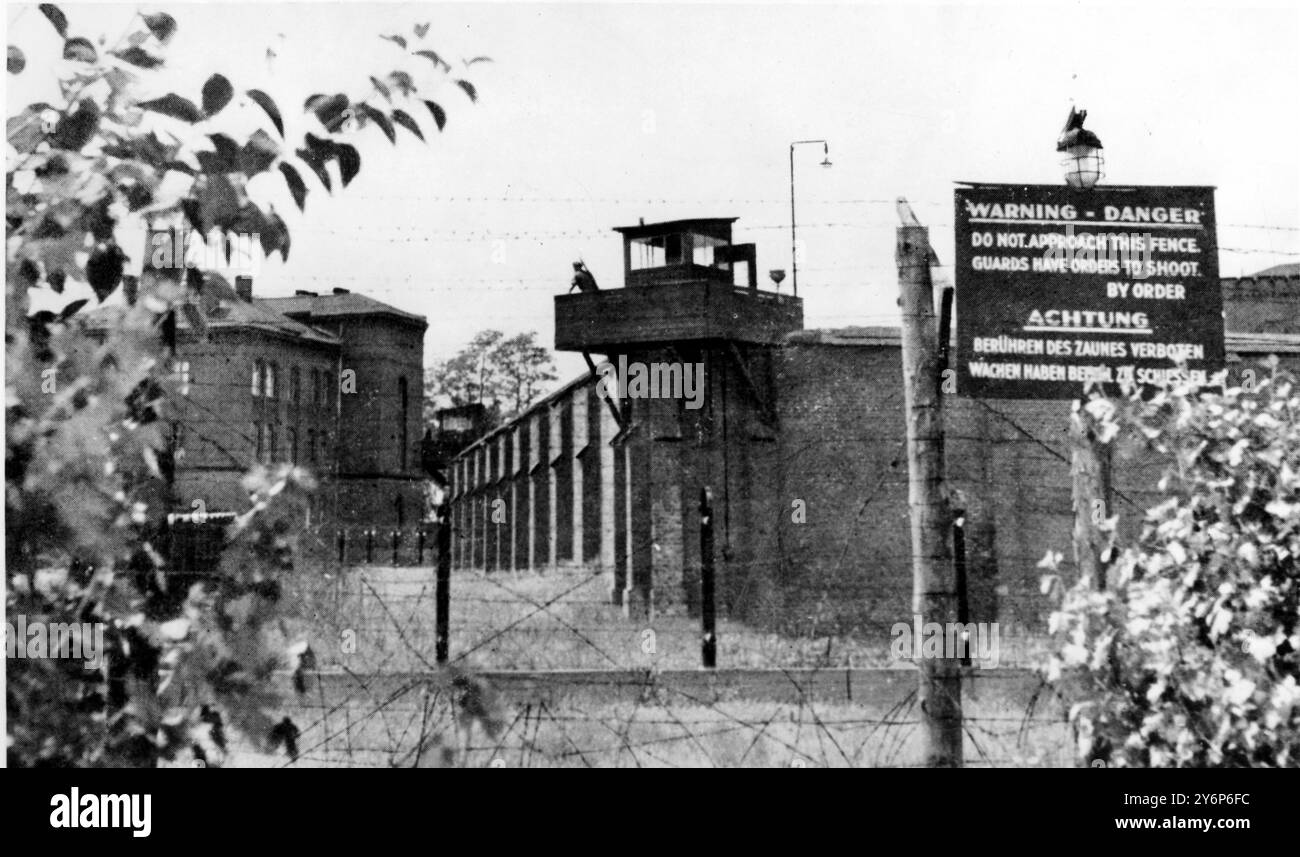 Un coin du mur de la prison de Spandau avec l'avis avertissement : danger : ne pas approcher de cette clôture. Les gardes ont l'ordre de tirer. Par ordre. La Tour de surveillance au centre est gardée par des gardes avec des gardes de machine. Rudolph Hess Banque D'Images