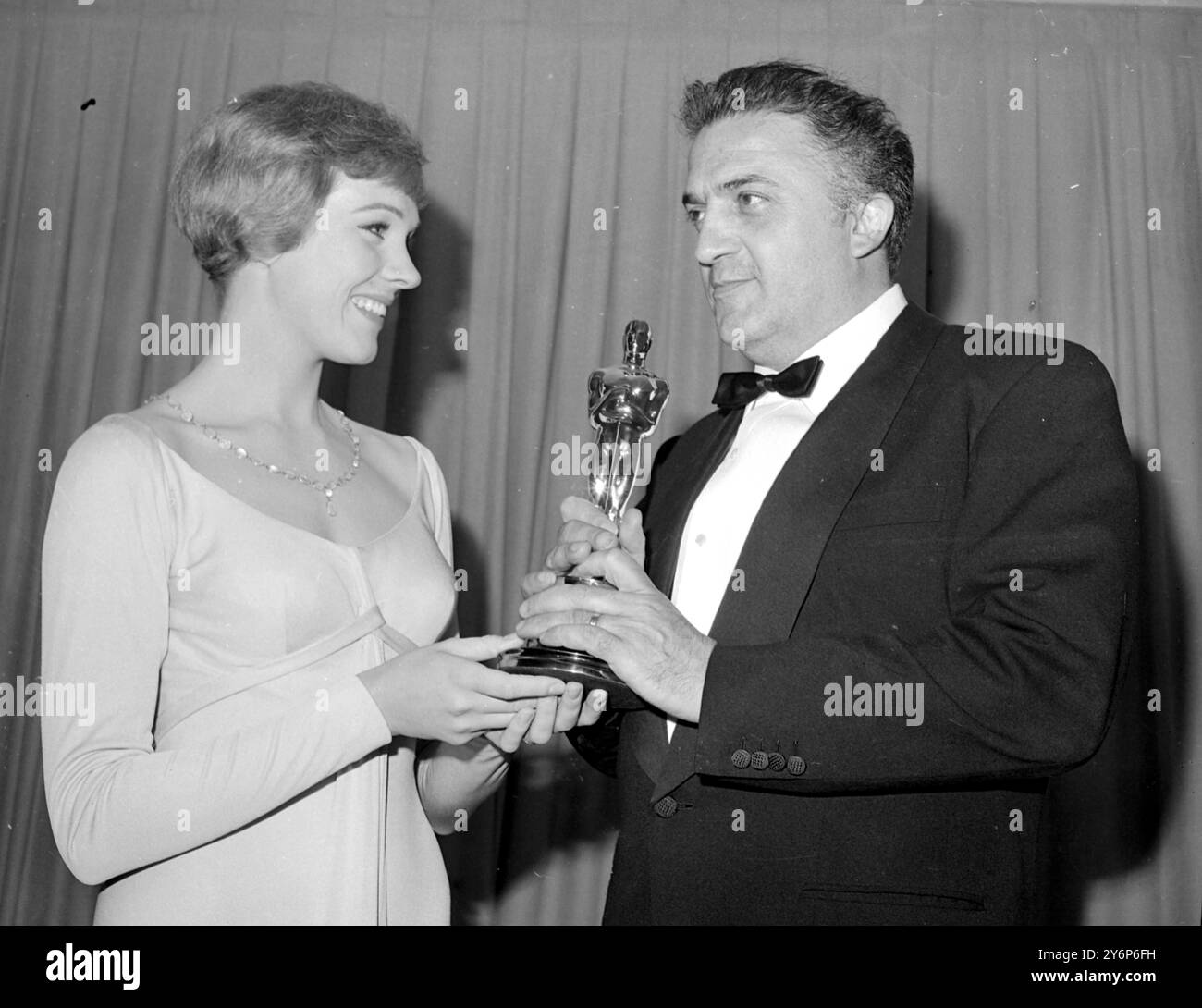 L'actrice chanteuse Julie Andrews présente au réalisateur italien Federico Fellini son Oscar pour son film 8 1/2 16 avril 1964 Banque D'Images