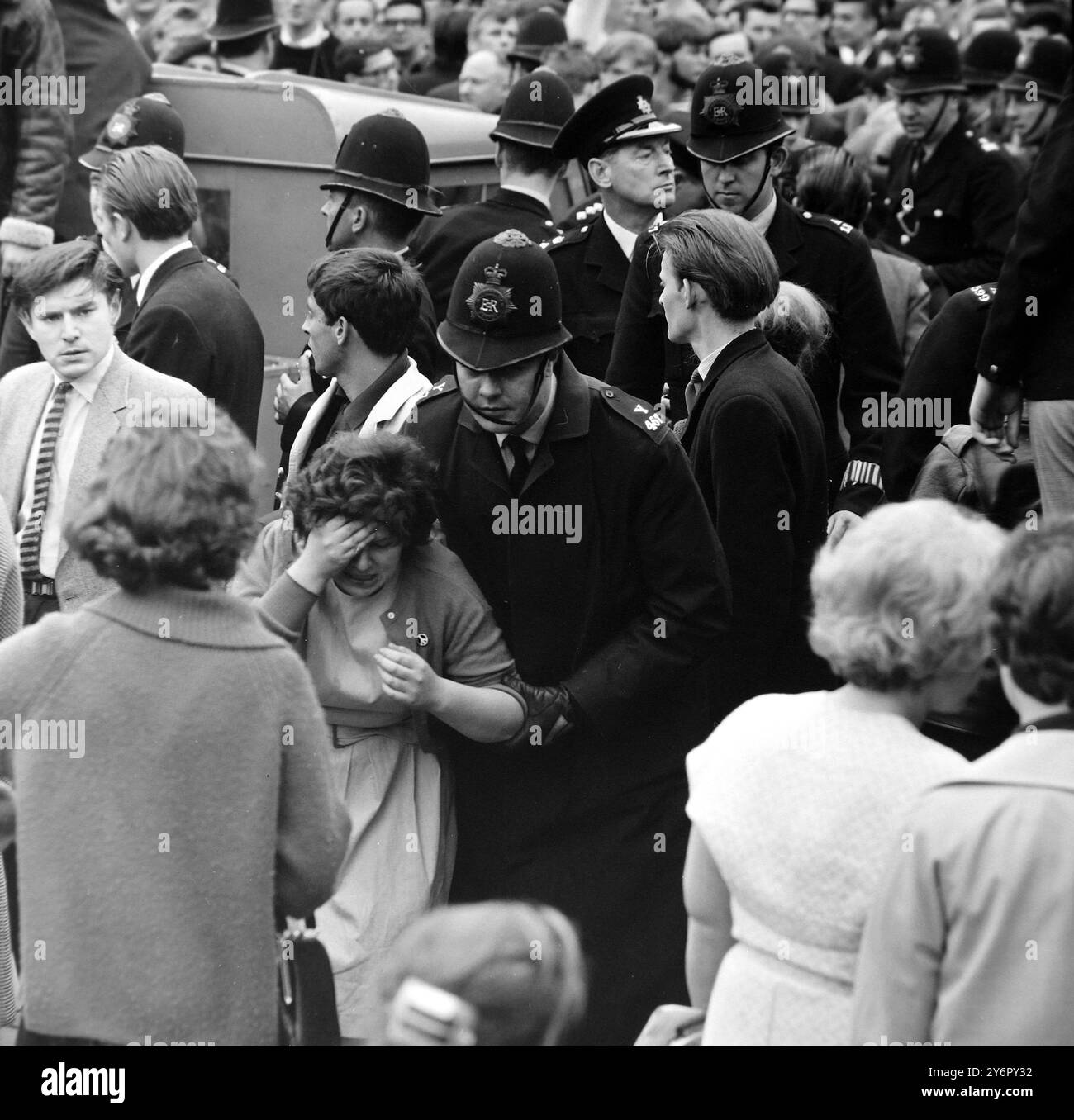 MANIFESTATION ANTI-JUIVE À LONDRES - UN POLICIER EMMÈNE UNE FEMME BLESSÉE ; 1ER JUILLET 1962 Banque D'Images