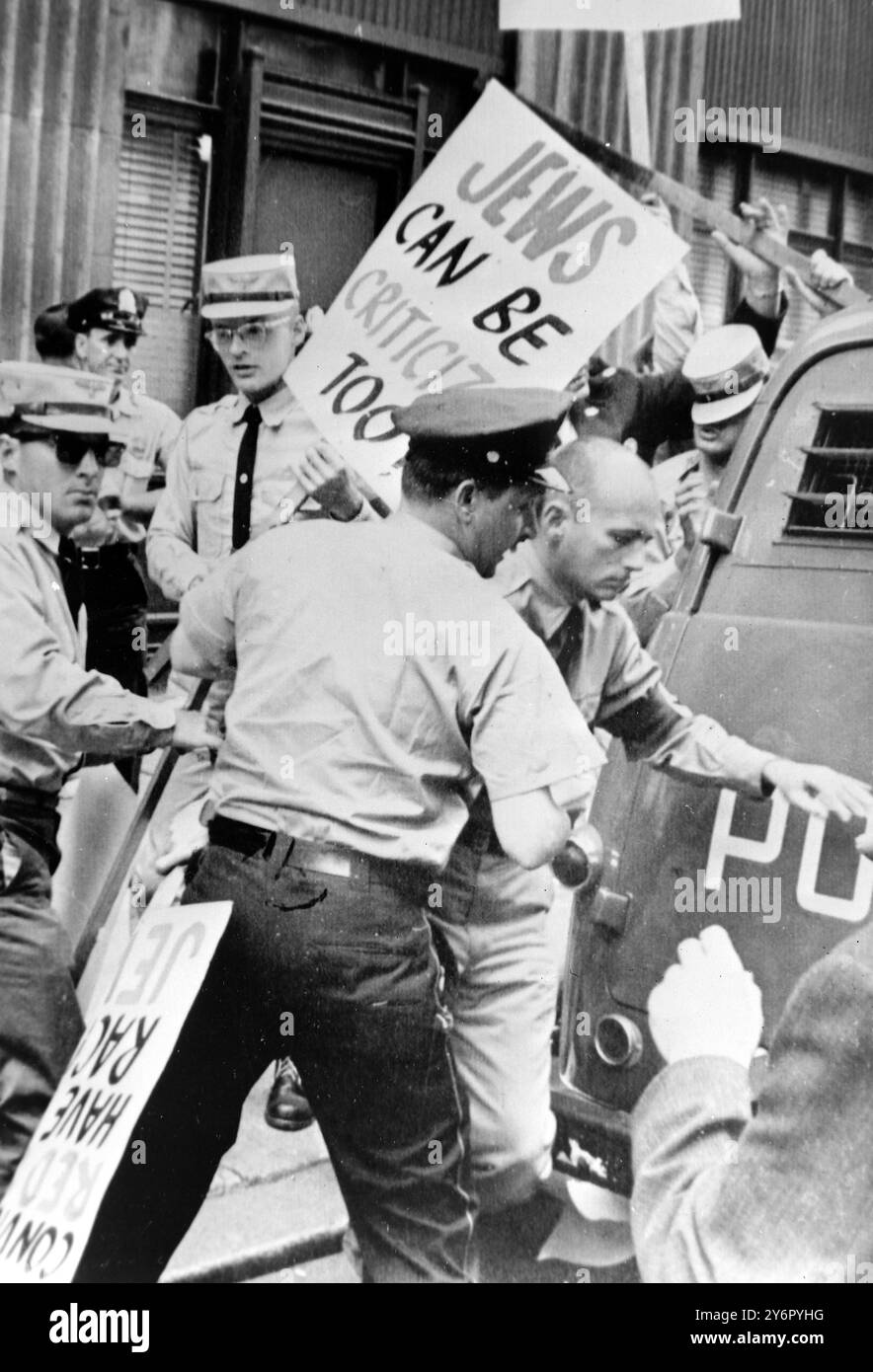 Philadelphie : des policiers escortent plusieurs membres du parti nazi américain dans un van ici après une émeute dans le centre de Philadelphie. Les membres du Parti , habillés en soldats de la tempête et portant des brassards swastika , ont piqué le siège d'une organisation juive quand une foule en colère a commencé à se bagarrer avec eux . La police a dispersé la manifestation et escorté les six hors de la ville. Aucune arrestation n'a été faite. 28 juin 1962 Banque D'Images