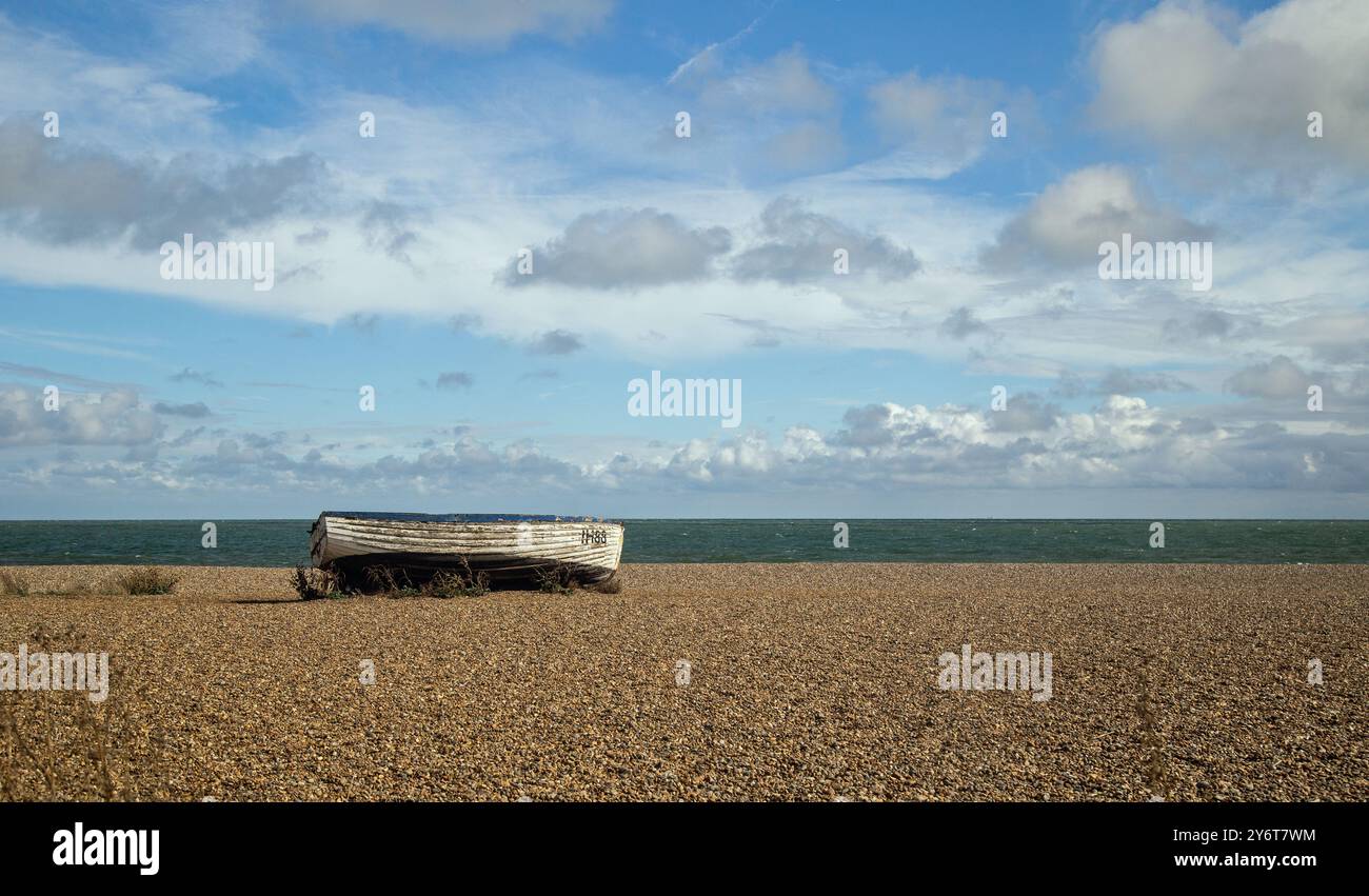 Aldeburgh, Suffolk, Angleterre, 8 septembre 2024, un bateau à rames repose sur la plage de galets par une journée ensoleillée Banque D'Images