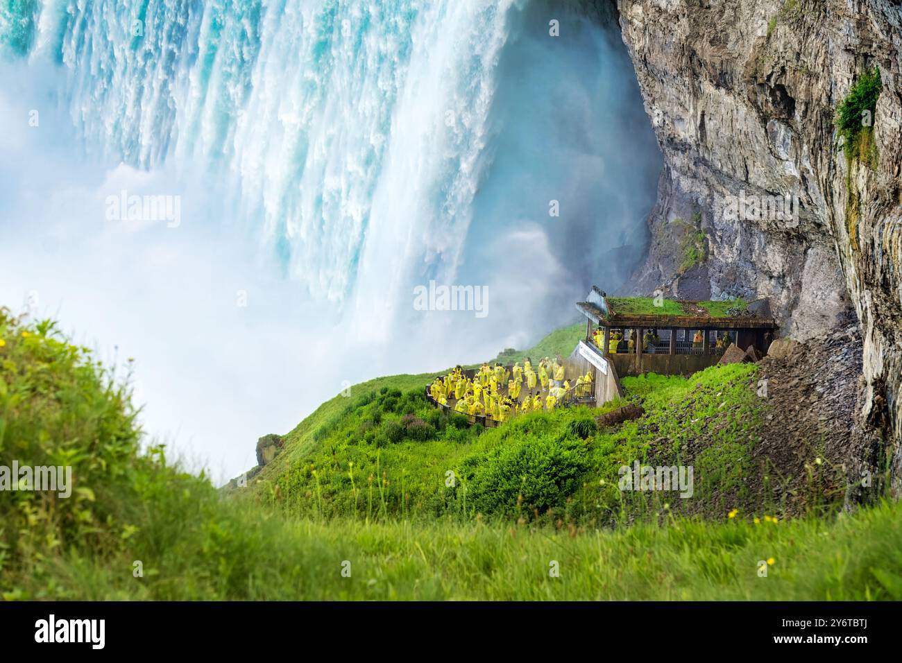 Les touristes en manteaux de pluie jaunes visitent les spectaculaires chutes Niagara Horseshoe au fond de la cascade lors de leur excursion Journey Behind the Falls Banque D'Images