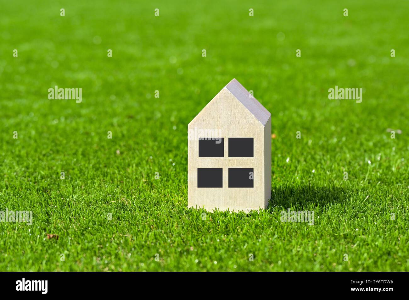 Maison modèle avec fenêtres isolées sur l'herbe d'une pelouse. Concept de logement. Personne. Copier l'espace. Banque D'Images Maison modèle avec fenêtres isolées sur l'herbe d'une pelouse. Concept de logement. Personne. Copier l'espace. Banque D'Images