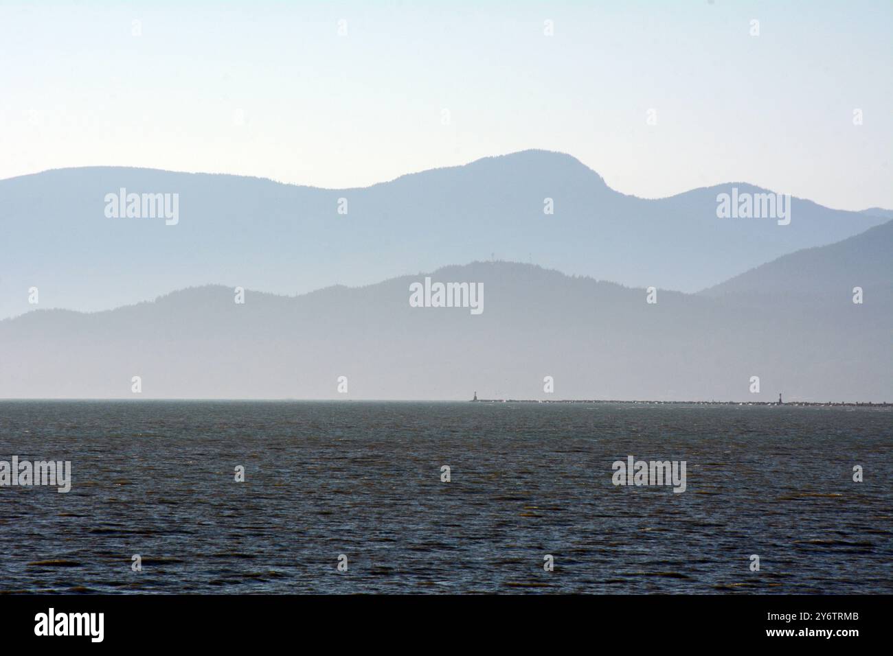 Silhouettes de coucher de soleil de la chaîne de montagnes Coast sur la Sunshine Coast et le détroit de Georgia vues de Richmond, Colombie-Britannique, Canada. Banque D'Images