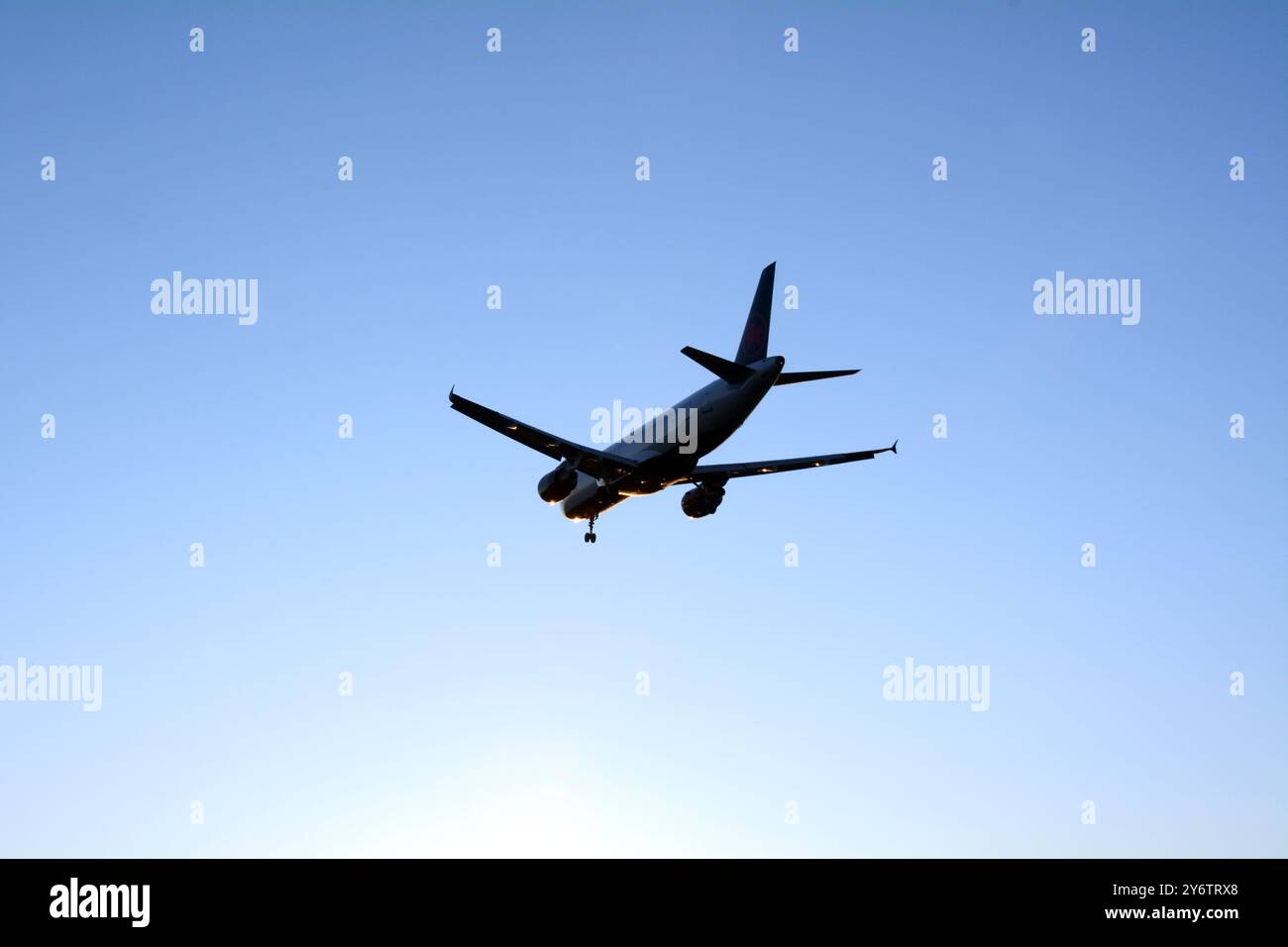 Un avion de ligne commercial arrivant pour un atterrissage à l'aéroport international de Vancouver au crépuscule, Richmond, Colombie-Britannique, Canada. Banque D'Images