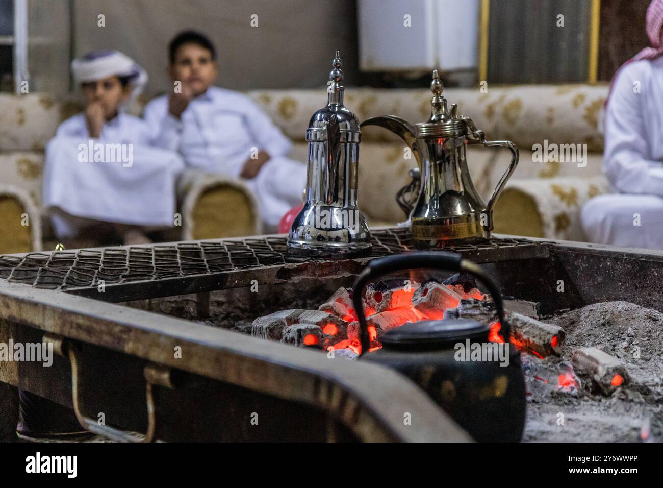 Bouilloires à café avec des membres de la tribu Yam en arrière-plan à Najran, Arabie Saoudite Banque D'Images