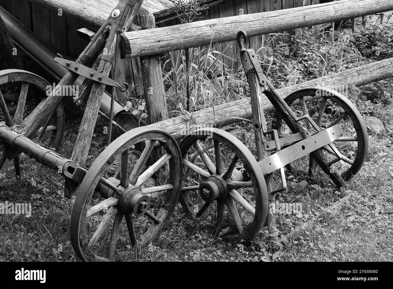 Une photo en noir et blanc d'un wagon roues en bois, posé à l'extérieur sur l'herbe. Banque D'Images