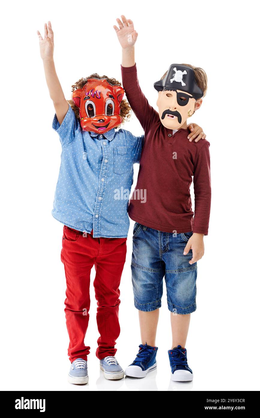 Enfants, amis et masque en studio pour la fête d'halloween avec pirate, animal et vague par fond blanc. Jeux, embrasser et les enfants avec câlin pour Banque D'Images