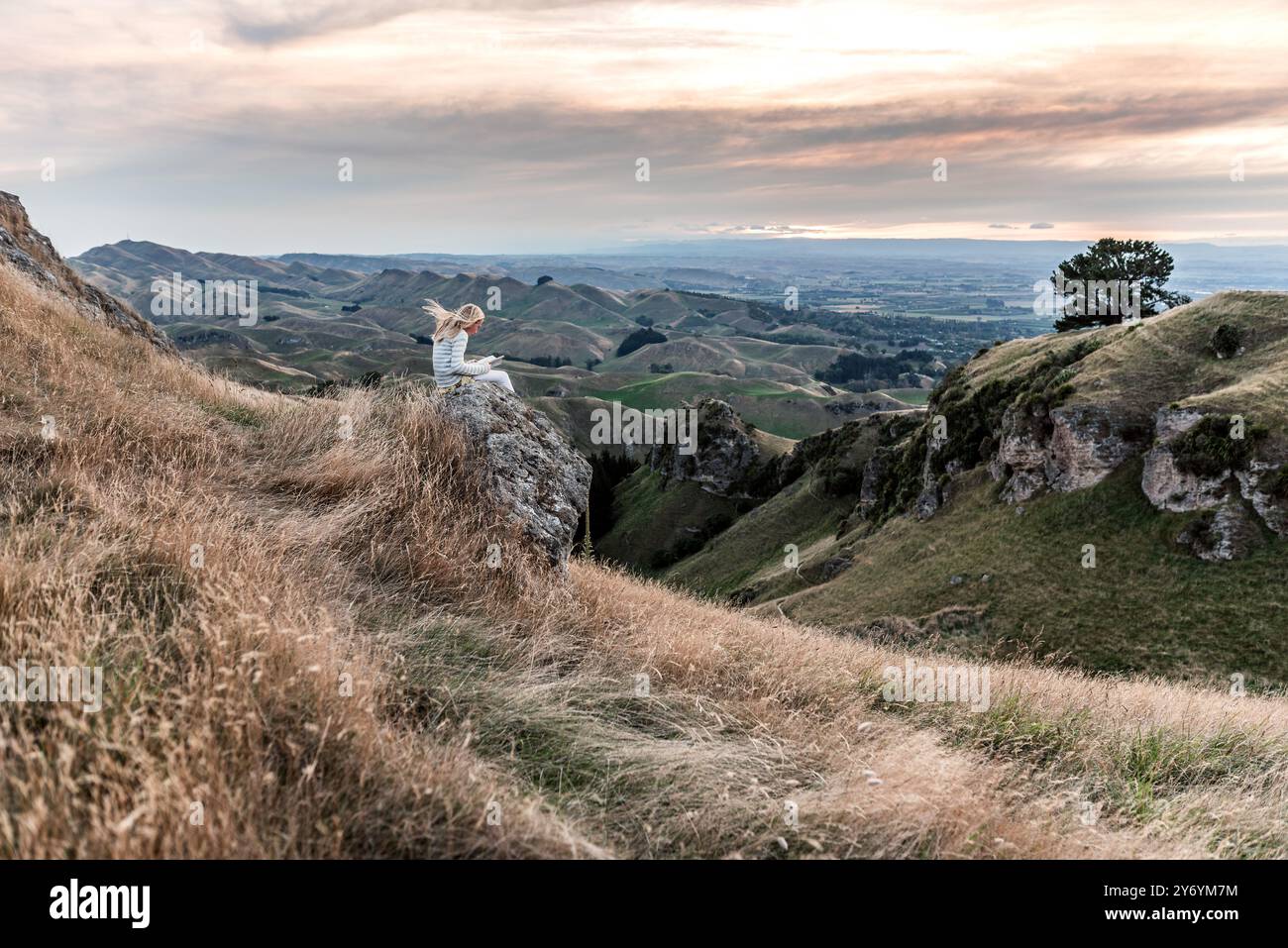 Fille assise sur la lecture de roche avec vue panoramique Banque D'Images