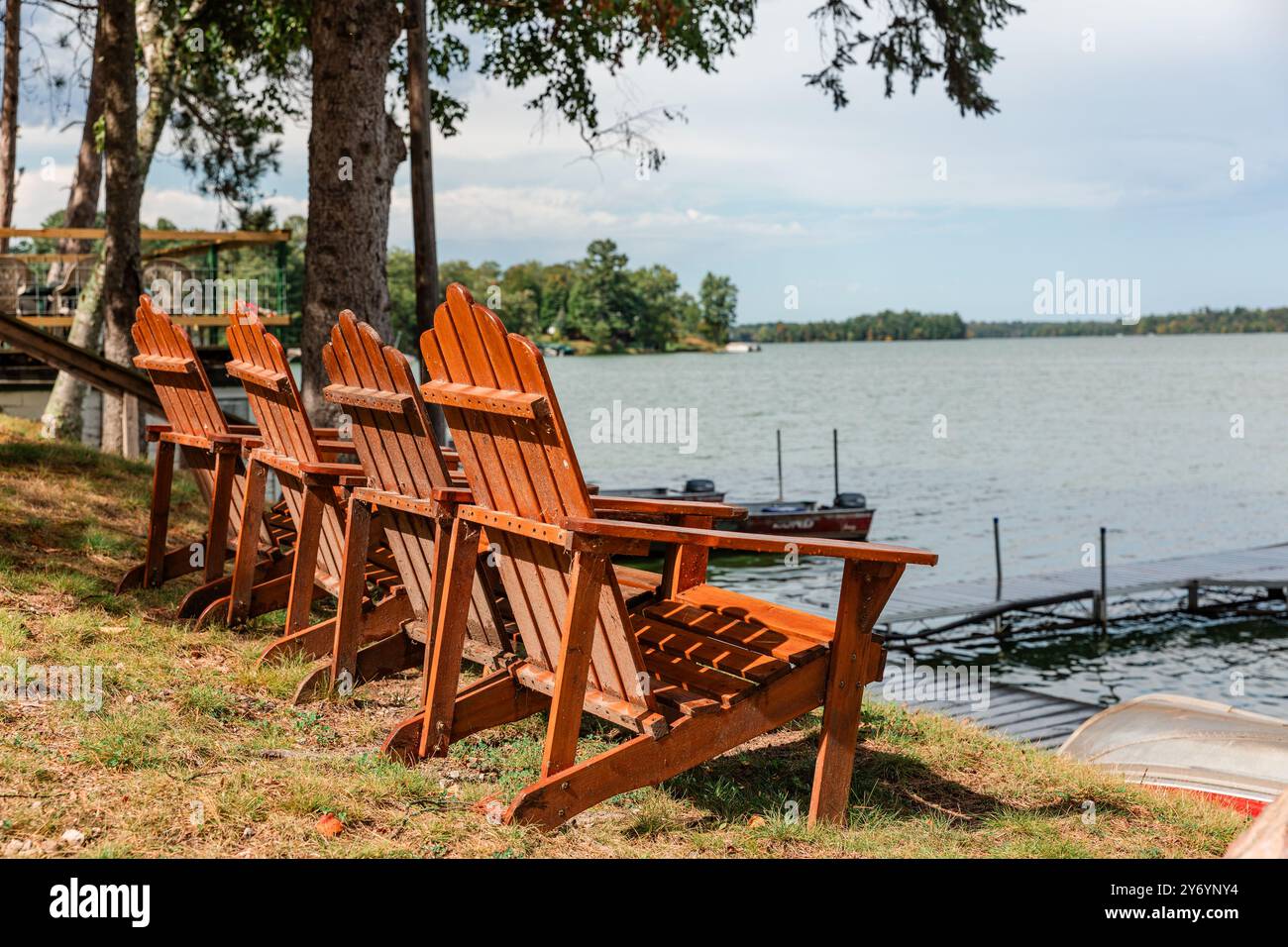 Chaises Adirondack face au lac au rivage Banque D'Images