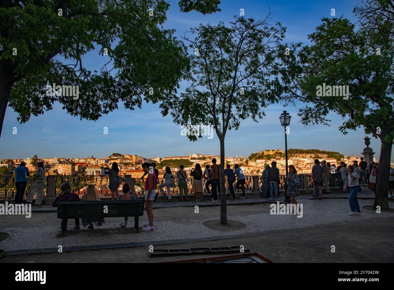 Une vue panoramique au coucher du soleil de Miradouro Sao Pedro de Alcantara d'un paysage urbain densément construit mis en évidence par le Castelo de Sao Jorge sur une colline . Banque D'Images