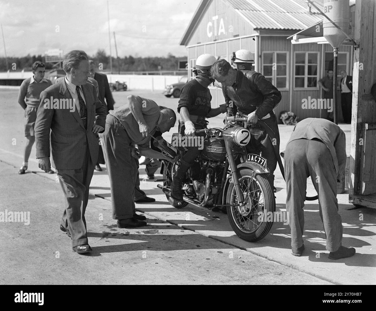 LA NOUVELLE MOTO BRITANNIQUE DE 100 KM/H TRIOMPHE DU DOLLAR cinq motards sombres ont égayé les perspectives du dollar britannique lorsqu'ils ont parcouru un parcours de 500 milles à des vitesses moyennes de plus de 90 milles à l'heure sur l'aérodrome de montlhery , près de Paris , en France . Entre eux, les cinq hommes ont prouvé le courage de trois nouvelles Triumph ' Thunderbird ' machines verticales bicylindre 650 c.c. - un modèle 1950 conçu avec le marché américain en vue. A la fin des 500 miles chaque machine a fait un dernier tour à plus de 100 miles à l'heure . Les motos - première production ' Thunderbirds ' étaient entièrement Banque D'Images