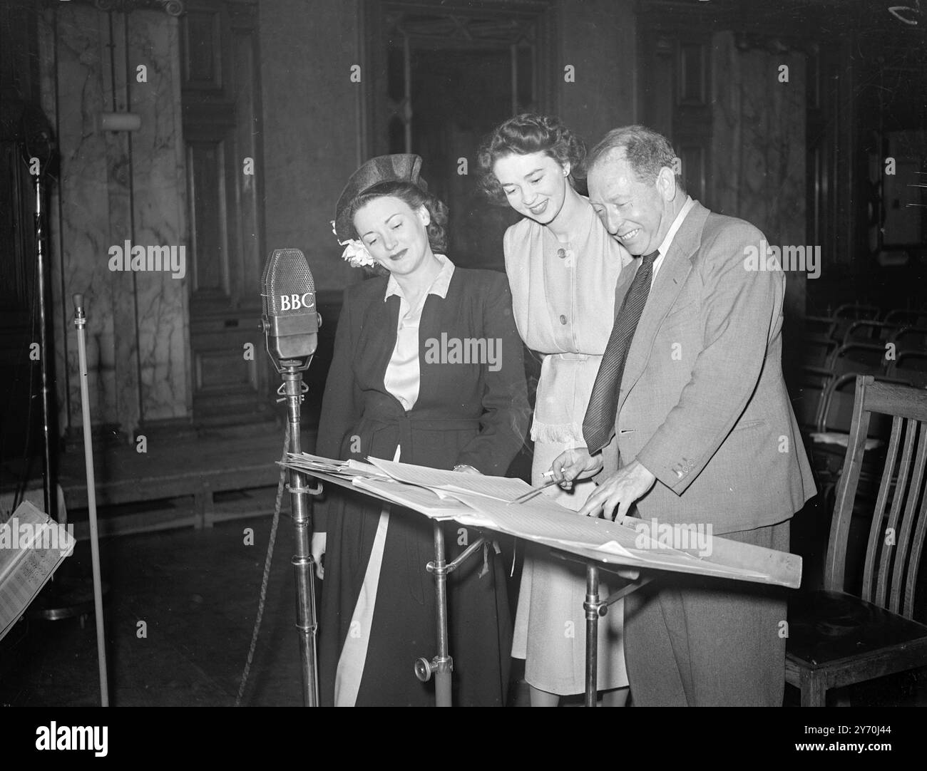 ÉMISSIONS DE LA CHANTEUSE AUSTRALIENNE DEPUIS LONDRES Glenda Raymond, la chanteuse australienne, diffusée dans l'émission " Music from the Movies " de la B.B.C. Light. L'émission était du B.B.C . Studios à Piccadilly, Londres. PHOTOS : Glenda Raymond , Elizabeth Tyson (productrice) et Louis Levy (chef d'orchestre) qui passent en revue la partition avant la diffusion d'aujourd'hui. 10 juillet 1949 Banque D'Images