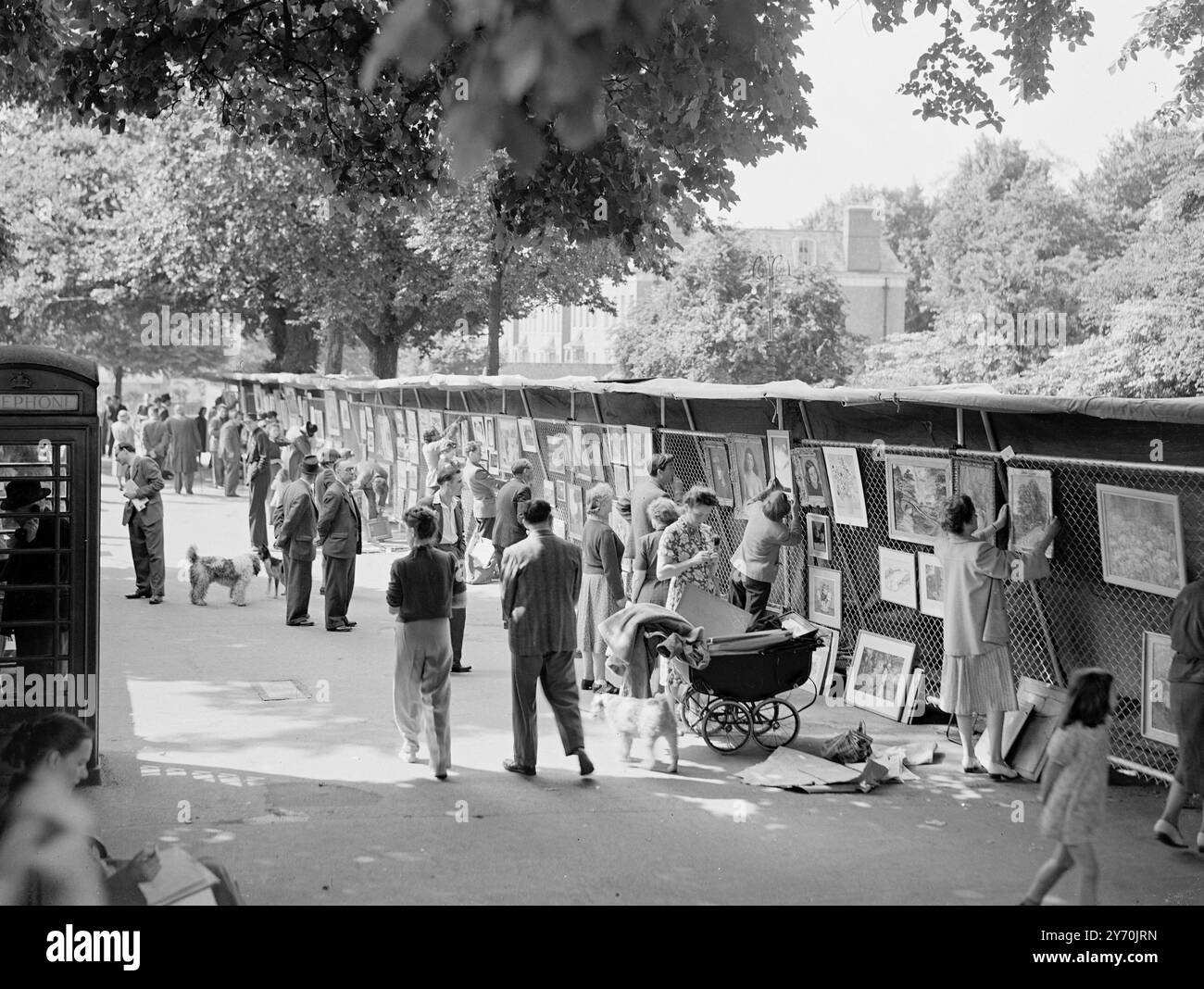 EN BAS DE HAMPSTEAD WAY AVEC L'ART EN PLEIN air - - - - une exposition d'art en plein air est organisée dans le cadre du festival de musique et d'arts de Hampstead ( Londres ). L'exposition est organisée sur la même ligne que celle tenue par le London County Council à Embankment Gardens , et durera jusqu'à la fin du mois d'août . Ici , une poussette apporte une touche domestique à l'exposition d'art , parmi les environs verdoyants . - - - - 18 juin 1949 Banque D'Images