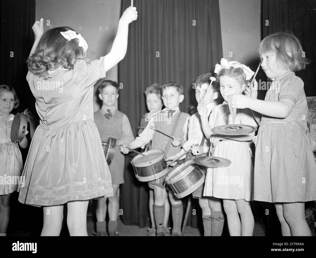 CUIVRES SONORES ... symboles Tinkling et tambours battants se combinent dans une symphonie de jeunesse dans l'Archway Central Hall , Highgate , Londres . Le groupe de percussions de Dominic's Infants ' School, N.W., 5. Sous la baguette vigoureuse de PAULINE SHEEHAN, cinq ans, et vu en compétition au North London Music Festival.- ils ont été entrés dans la classe pour le groupe de percussions avec des joueurs de huit ans et moins . 18 mai 1949 Banque D'Images