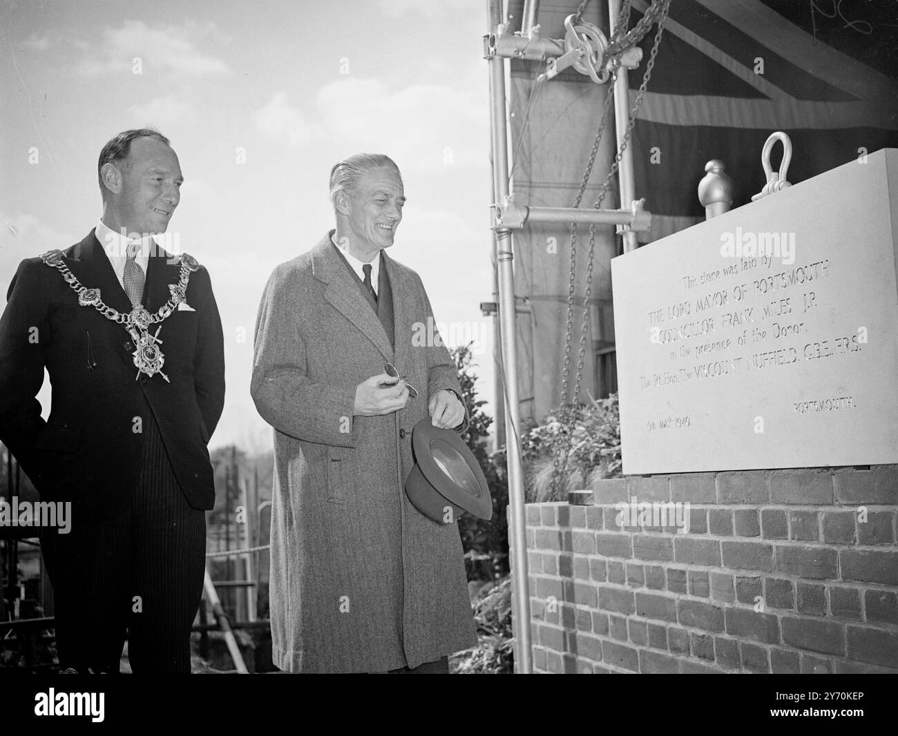 LORD NUFFIELD VOIT LA PIERRE DE FONDATION POSÉE LORD NUFFIELD, constructeur automobile et philanthropes , sourit à l'inscription sur la pierre de fondation du Nuffield United services Officers Club , Portsmouth , posée lundi par le maire de Portsmouth , conseiller FRANK MILES ( à gauche ) . 9 mai 1949 Banque D'Images