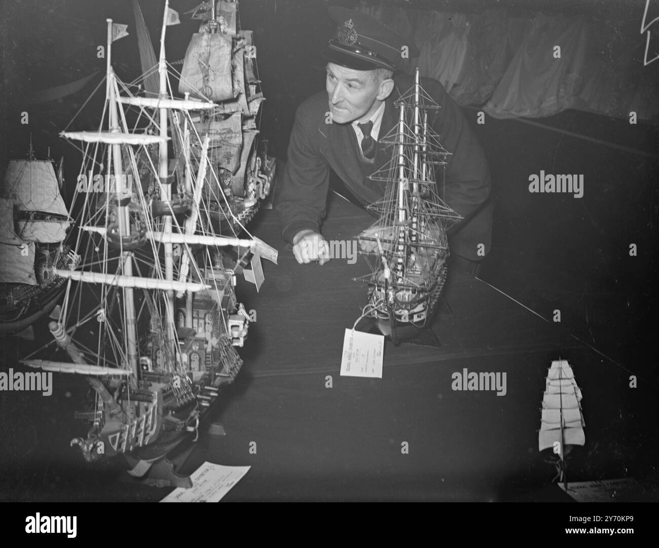 LE BUREAU DE POSTE TIENT L'EXPOSITION DE LOISIRS Postman F. Nicholls , de Rotherhithe , est vu admirant des galions modèles qui étaient exposés au bureau de poste All - Regional Hobbies Exhibition , au King Edward Building , Londres . Banque D'Images