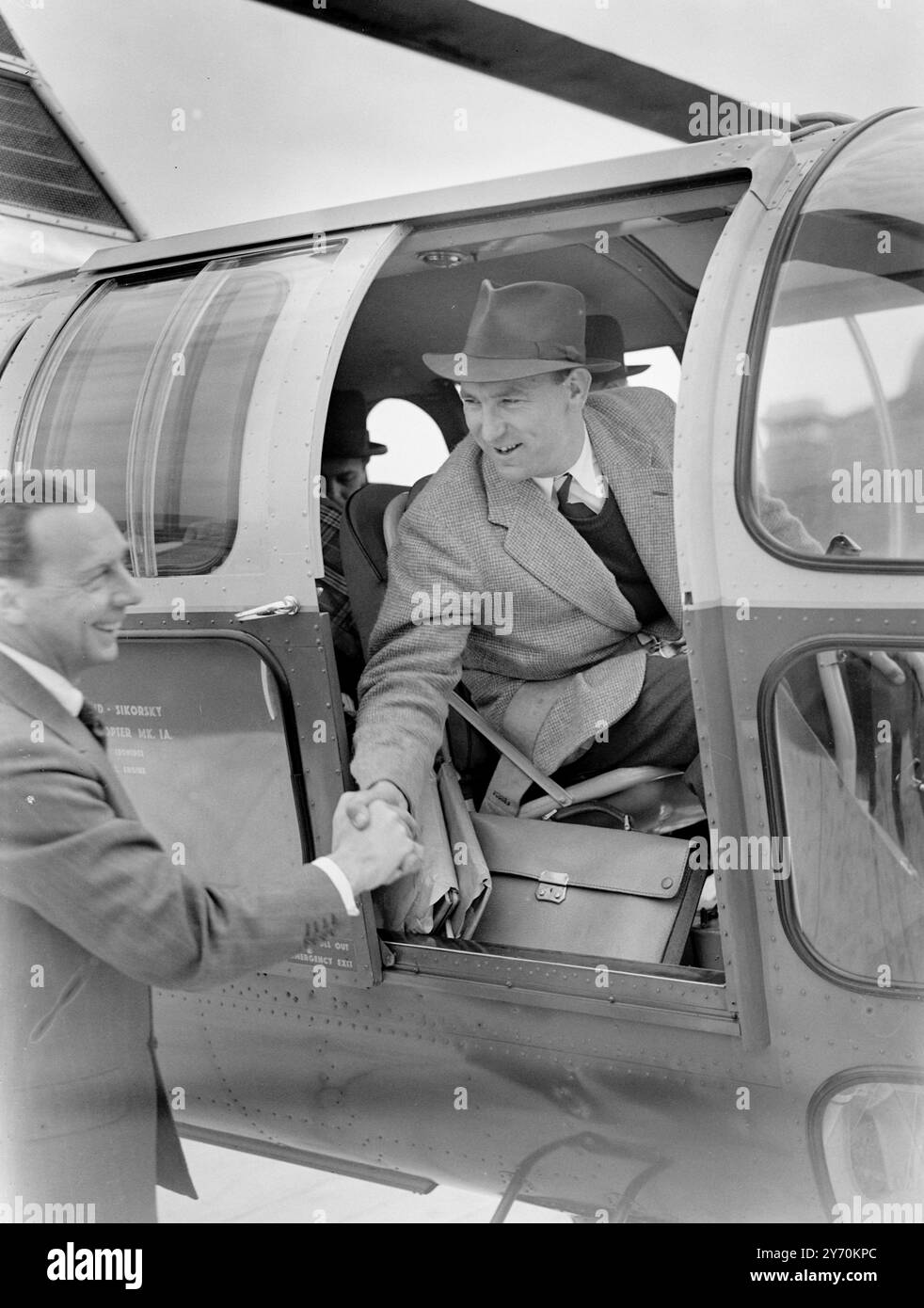 UN HÉLICOPTÈRE RELIE LONDRES ET PARIS Un hélicoptère Westland - Sikorsky a décollé du toit des garages Metropolis , adjacent à Olympia ( Londres 0 pour Paris . Ce nouveau service est conçu pour soulager les passagers aériens des problèmes de transport terminal qui surviennent lors de voyages aériens normaux. Les passagers potentiels sont capables de conduire presque jusqu'à la piste d'air du toit , de monter à bord de l'hélicoptère , et en seulement deux heures et demie se retrouvent au coeur de la capitale française . PHOTOS :- Mr . Alan Bristow , pilote de l'hélicoptère , photographié avant de décoller du toit Banque D'Images UN HÉLICOPTÈRE RELIE LONDRES ET PARIS Un hélicoptère Westland - Sikorsky a décollé du toit des garages Metropolis , adjacent à Olympia ( Londres 0 pour Paris . Ce nouveau service est conçu pour soulager les passagers aériens des problèmes de transport terminal qui surviennent lors de voyages aériens normaux. Les passagers potentiels sont capables de conduire presque jusqu'à la piste d'air du toit , de monter à bord de l'hélicoptère , et en seulement deux heures et demie se retrouvent au coeur de la capitale française . PHOTOS :- Mr . Alan Bristow , pilote de l'hélicoptère , photographié avant de décoller du toit Banque D'Images
