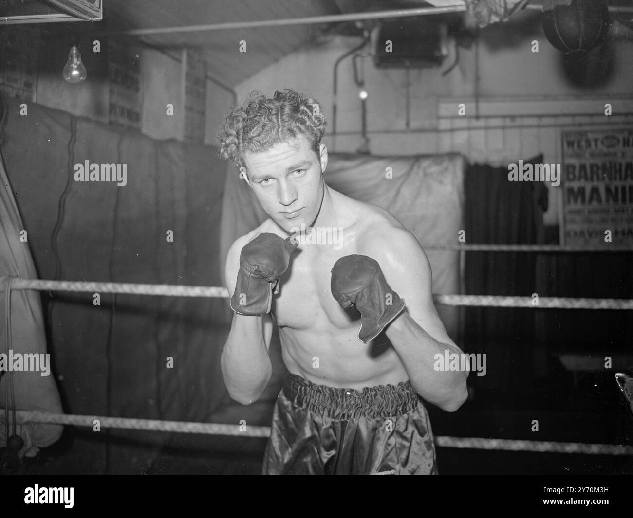 HEAVYWEIGHT POUR REGARDER Heavyweight boxer avec un avenir très promotionnel prédit pour lui , est de 6 pieds 3 pouces Frank Ronan , vu ici dans une attitude de sparring . Fils de London Undrground Railway Workers , il a 21 ans et pèse 14 pierres. Au Empress Hall , Londres , le 3 mai, Ronan rencontre Jack Gardner , de Market Harborough , dans un concours qui devrait s'avérer d'un grand intérêt . 9 avril 1949 Banque D'Images